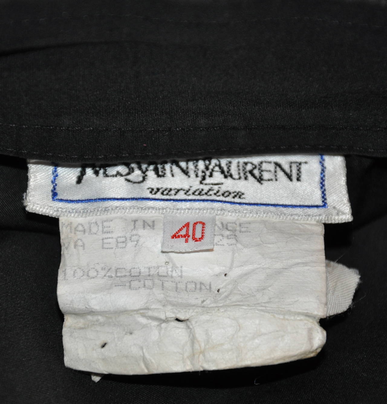 La jupe en coton noir Yves Saint Laurent est rehaussée de sa signature gravée 