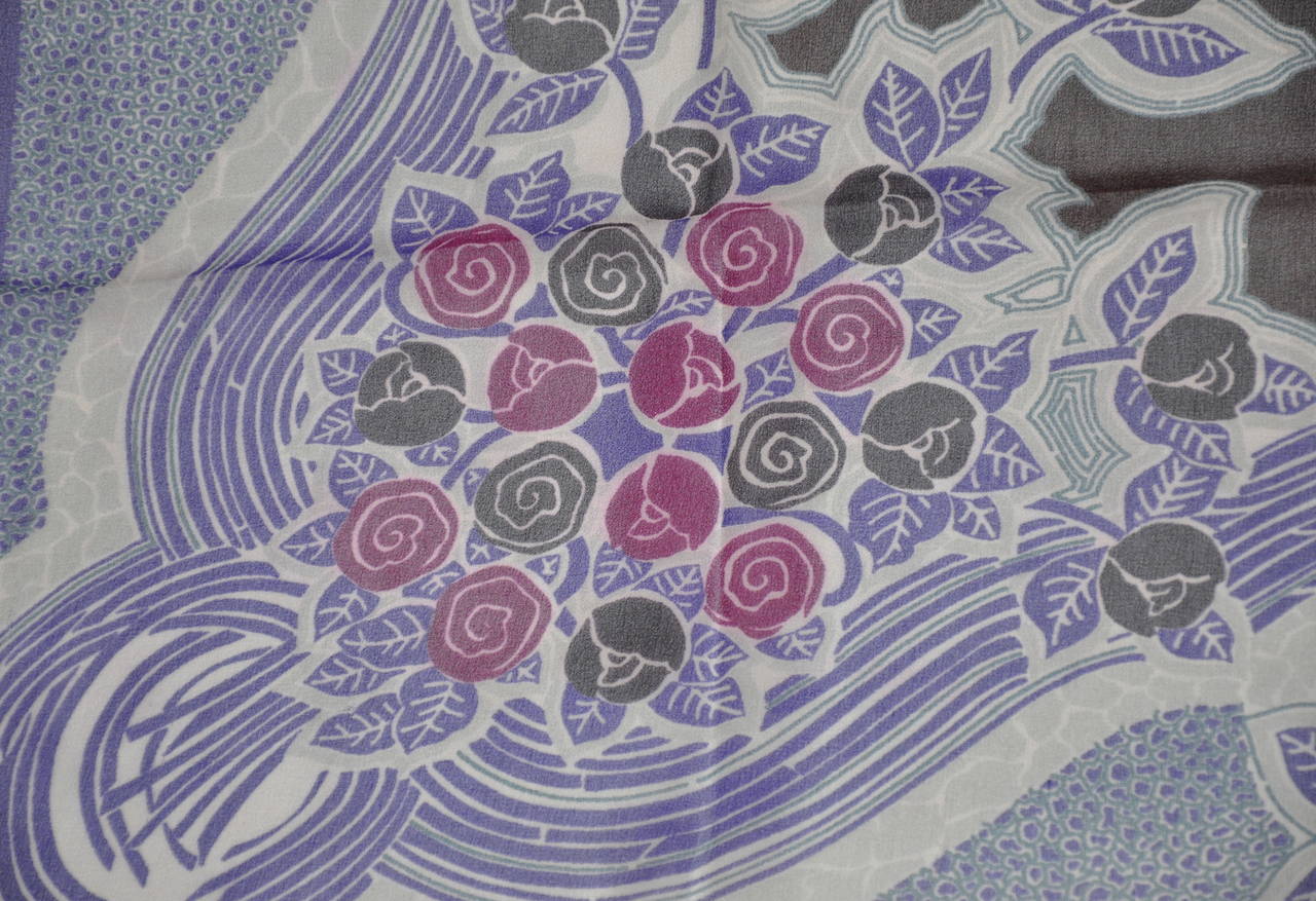 Esta maravillosa mezcla de ciruelas, violetas, azules y crema conforma el pañuelo de gasa de seda con estampado floral. El pañuelo mide 33