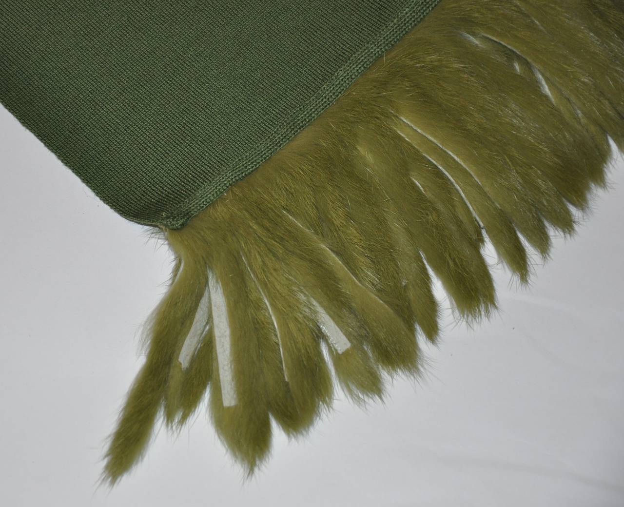 This wonderfully warm olive green merino wool jersey scarf is accented with matching fur/suede in olive green fringe. The scarf measures 21