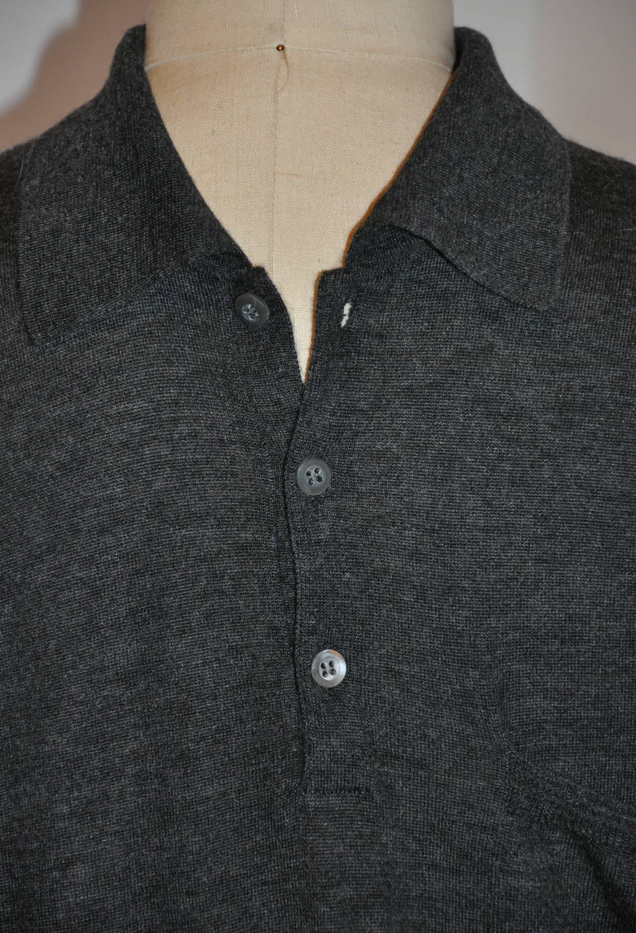 Prada's wonderfully soft cashmere in charcoal pullover is sized 50 Italy. The front has a single breast pocket, along with three buttons.
   The shoulders measures 18