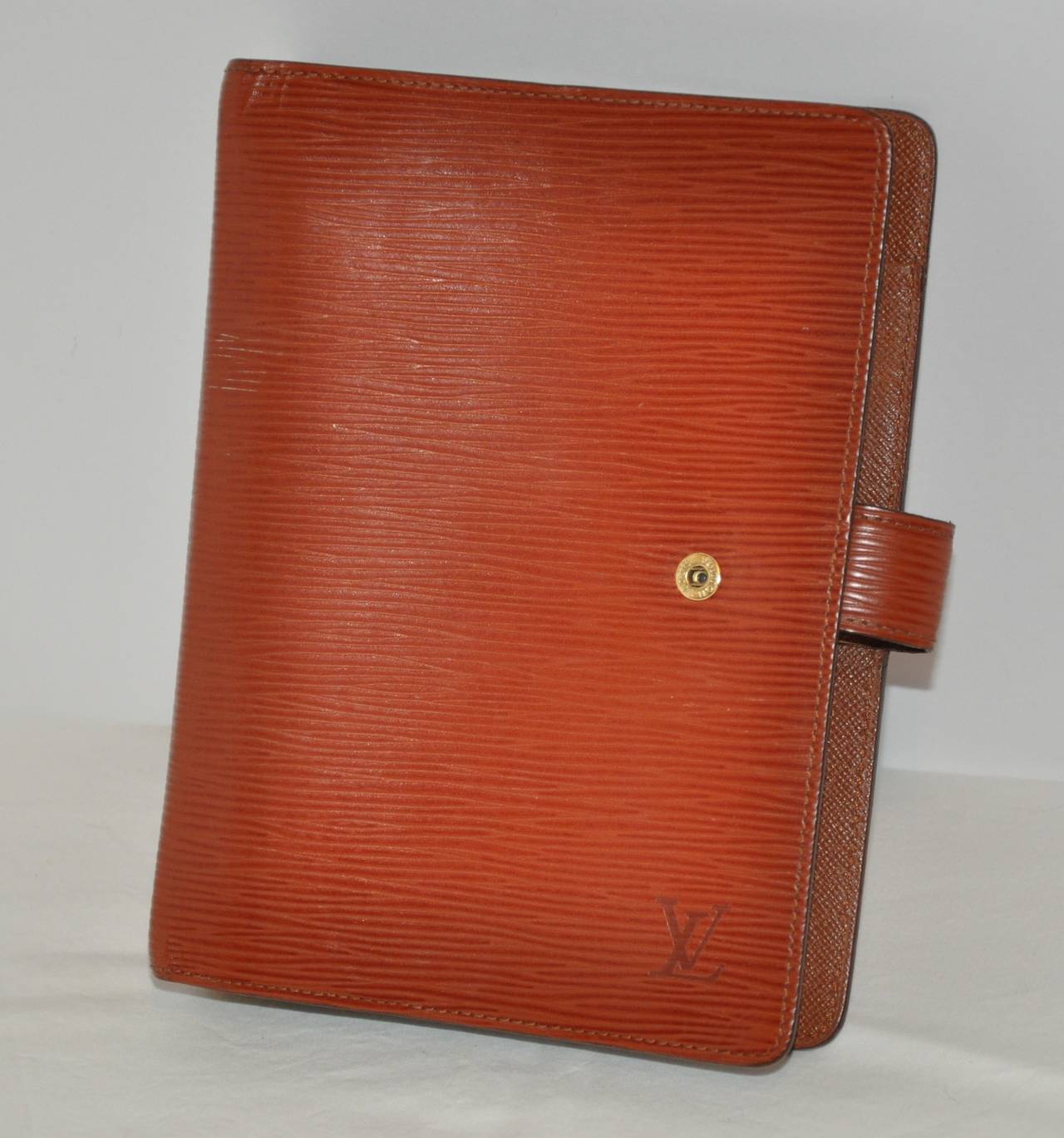 Louis Vuitton's textured warm brown adjenda notebook has six (6) rings accented with space for 6 business cards inserts, and also a section for your loose paper notes. The width measures 5 1/2