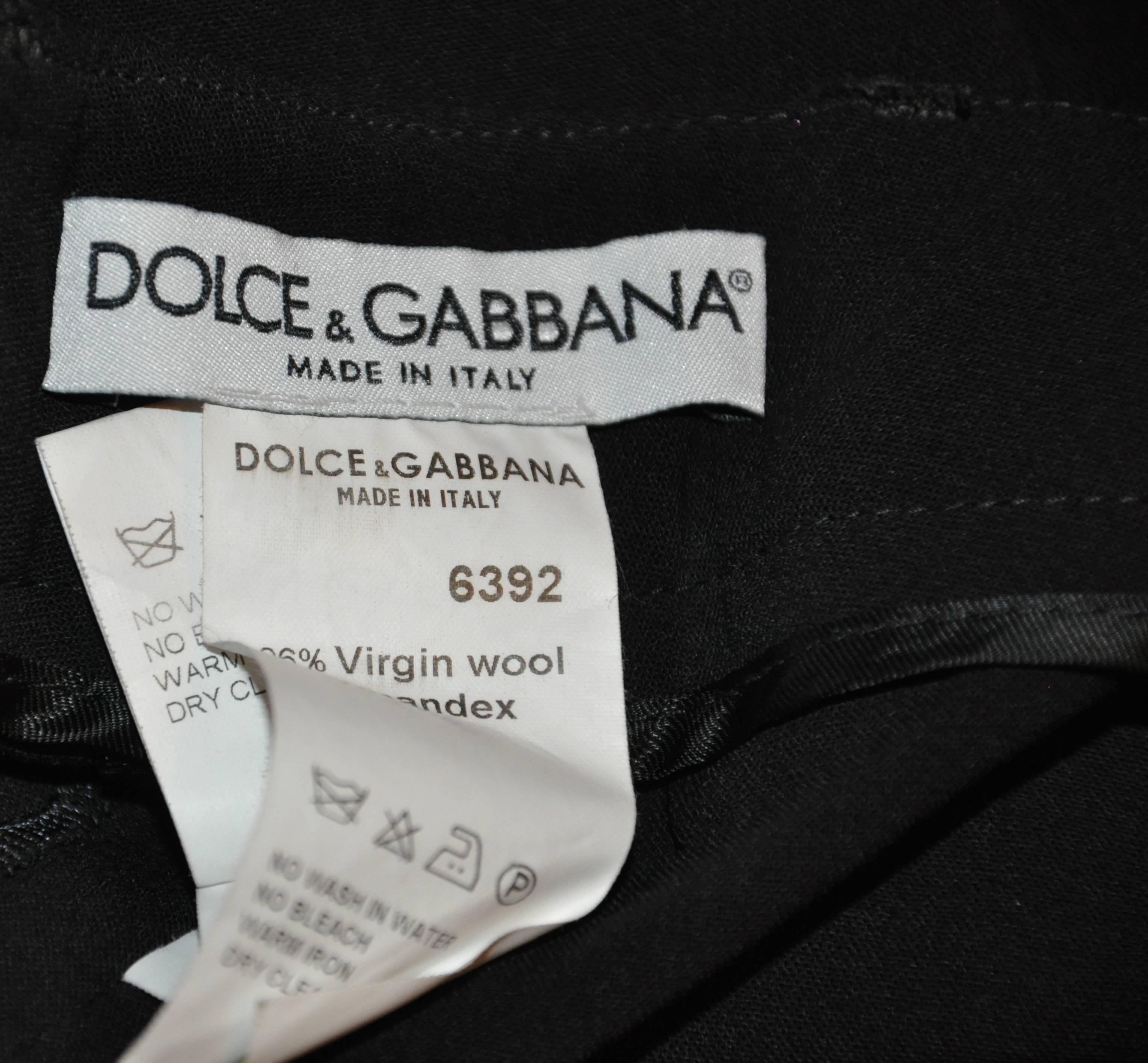           Dolce & Gabbana black relaxed-fit trousers are accented with cuff finishing on the legs. The waist measures 29