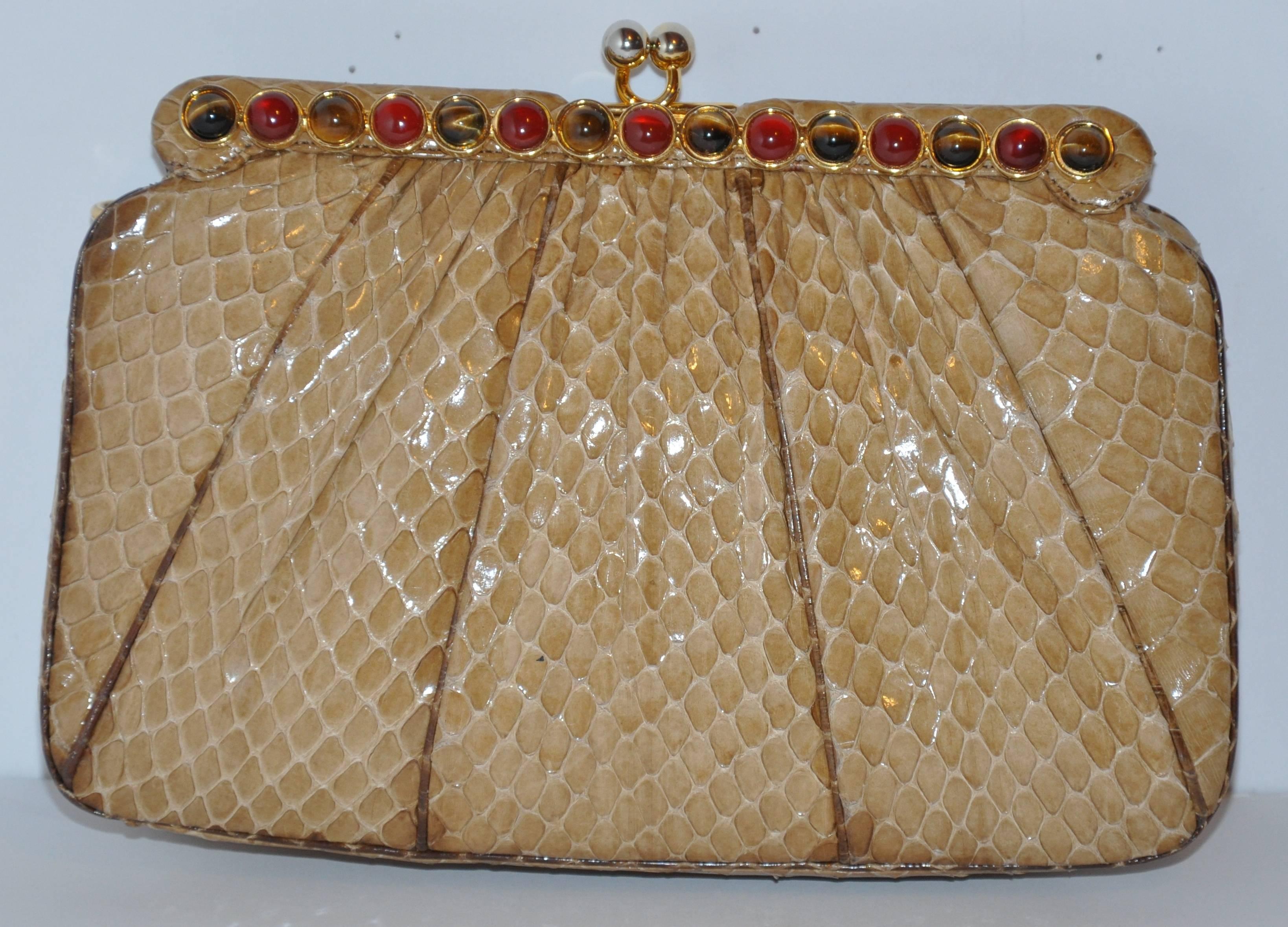            Judith Leiber's wonderfully detailed beige python evening clutch has the optional use of a evening shoulder bag with their removable straps of python and gold hardware. The evening clutch is highly detailed with tiger's eye and garnet