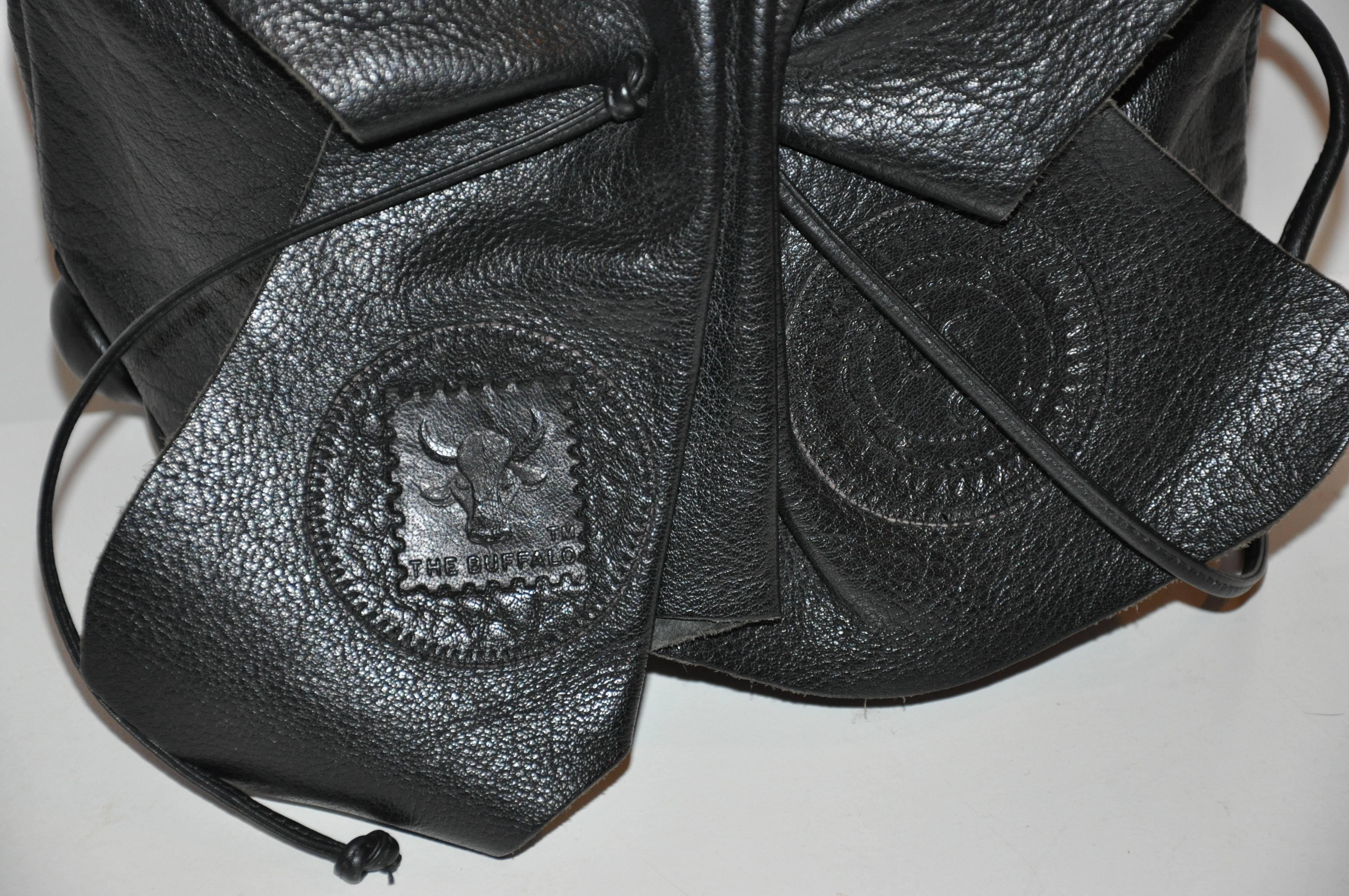           Carlos Falchi's signature black textured calfskin adjustable drawstring shoulder bag measures 9