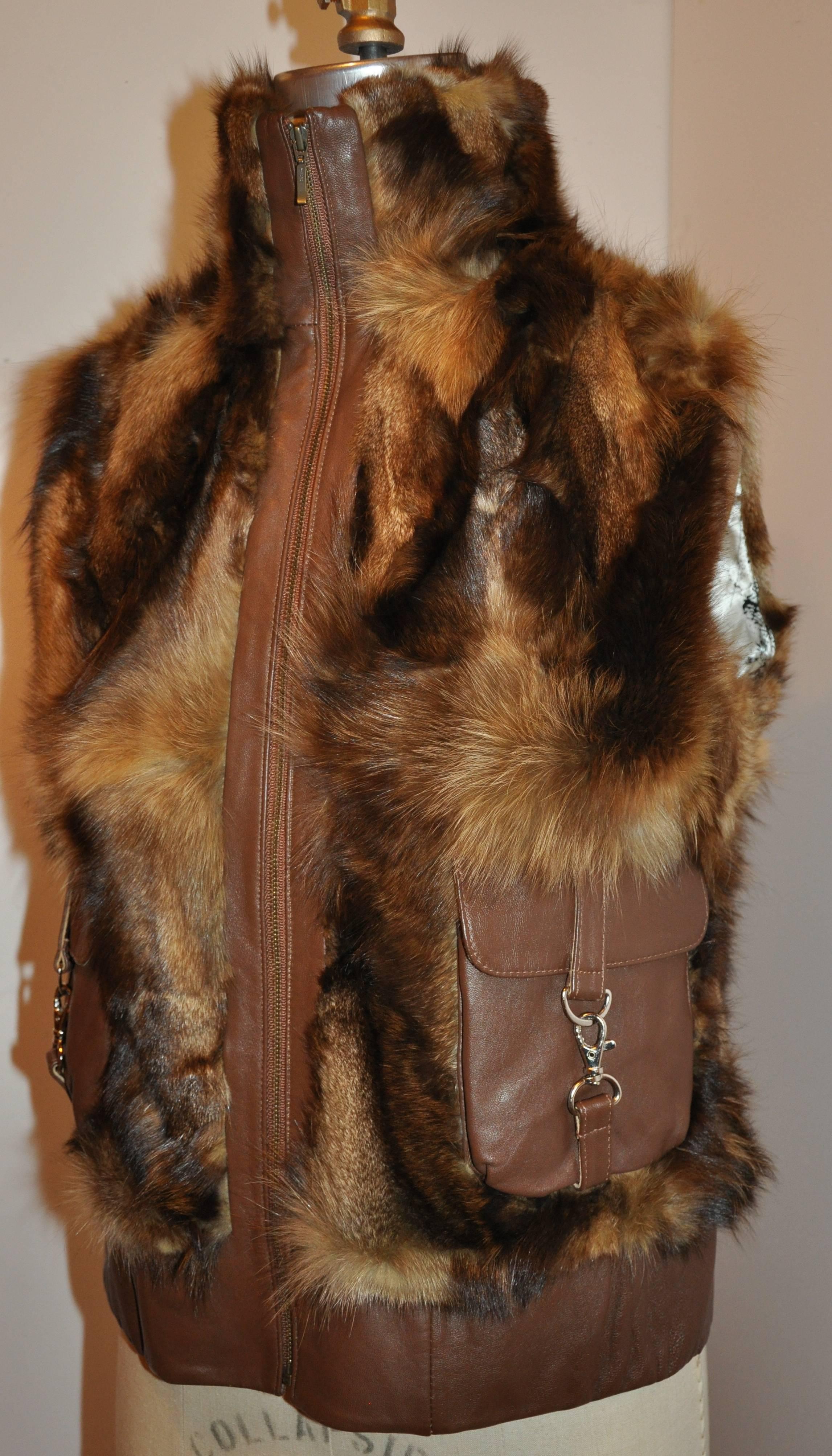         High collar zippered front fur vest is accented with brown leather throughout. The high collar measures 4