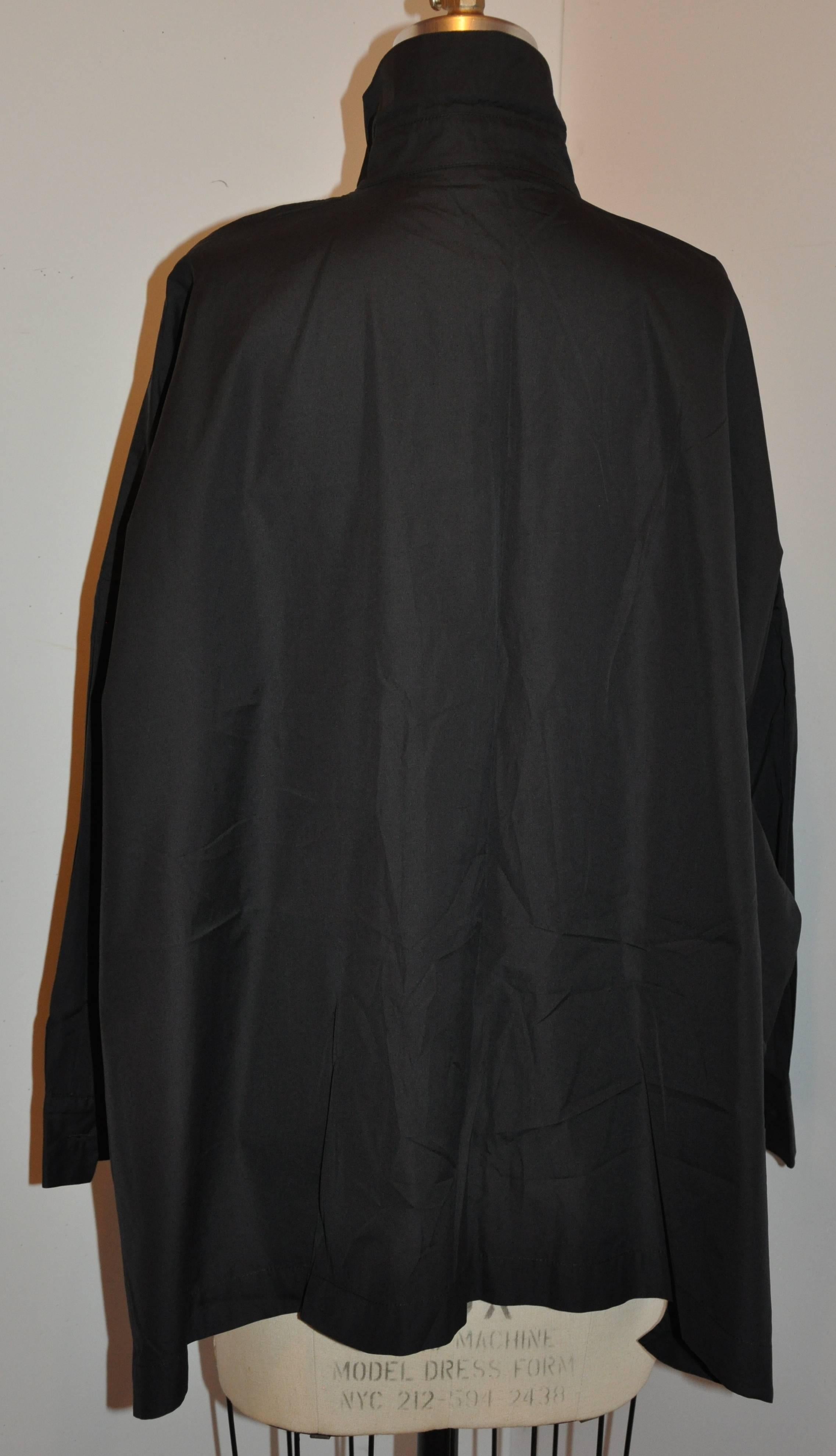         Die schwarze Oversize-Jacke von Eskandar für Bergdorf Goodman aus Baumwolle im Smock-Stil hat zwei aufgesetzte Taschen auf der Vorderseite. Die Vorderseite hat sechs Knöpfe in passendem Schwarz. Die Seiten sind geschlitzt.
        Die