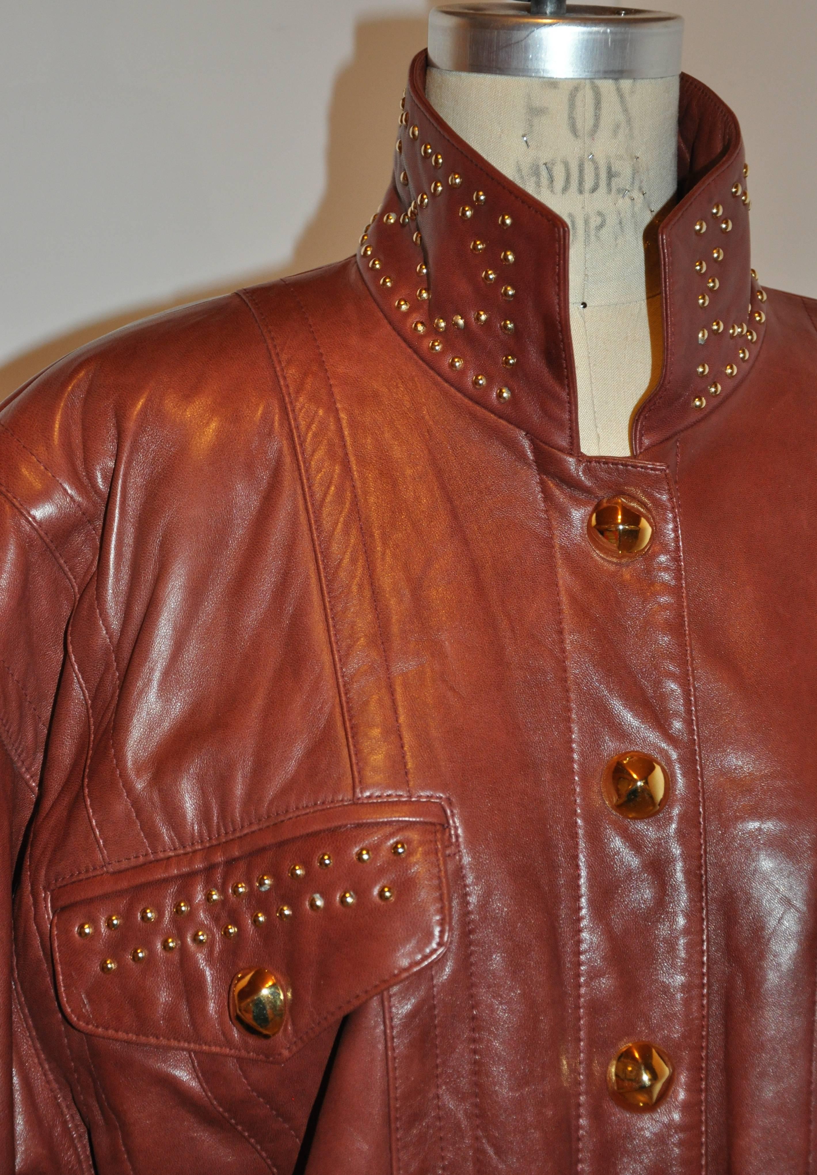        Margaretha Ley for Escada wonderfully rich brick-tone lambskin leather jacket is detailed with gold studs embellishments on the collar and two front set-in pocket flaps. The front is accented with gold button-like studs covering the actual