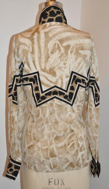           Escada multi-print silk blouse is accented with leopard print. The front length measures 22 1/2