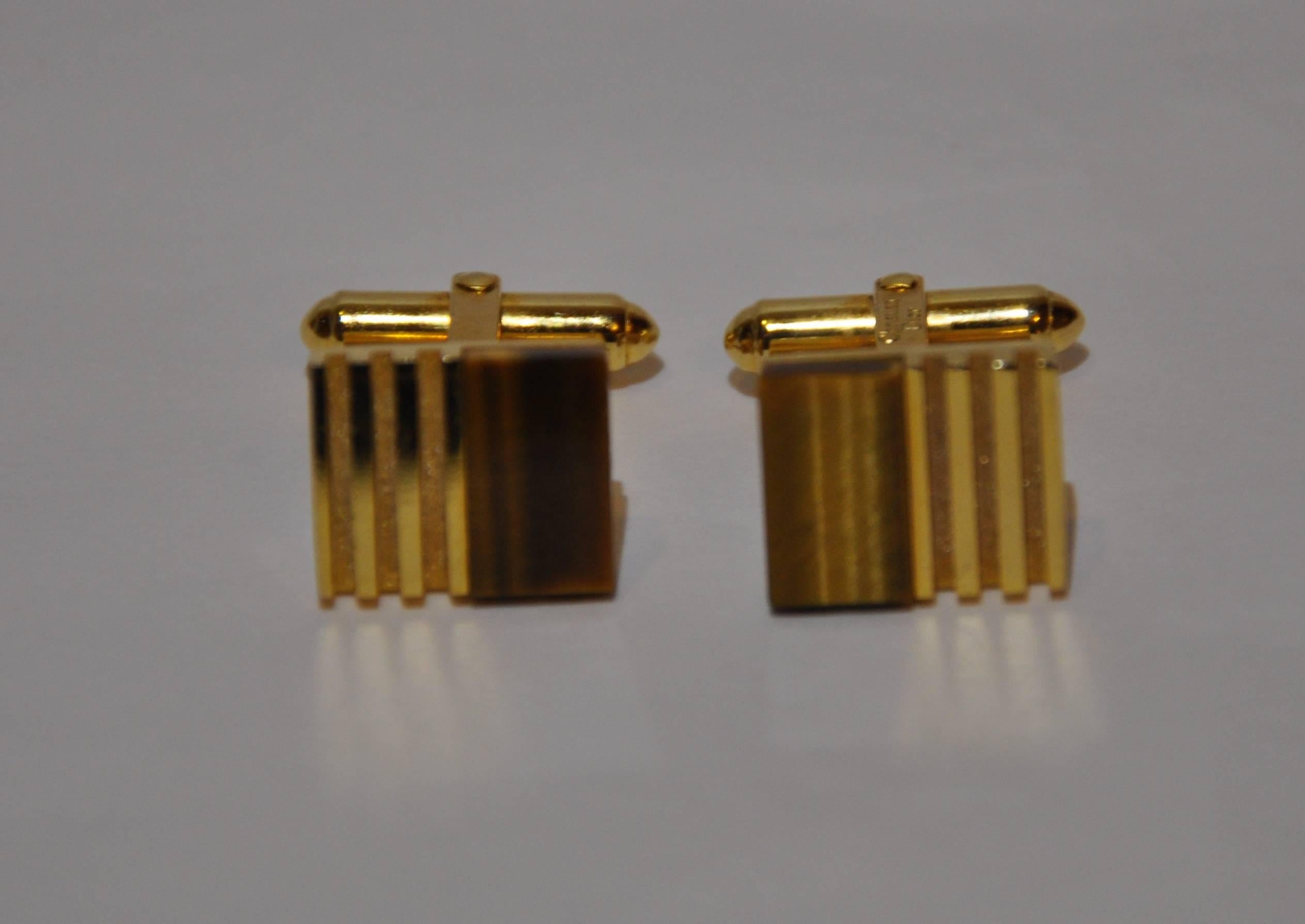        Christian Dior wonderfully elegant men's polished gold tone vermeil finished hardware cufflinks are accented with "Tiger Eye" stone. Etched with their signature name Christian Dior, these measures 5/8" x 1/2", and a depth