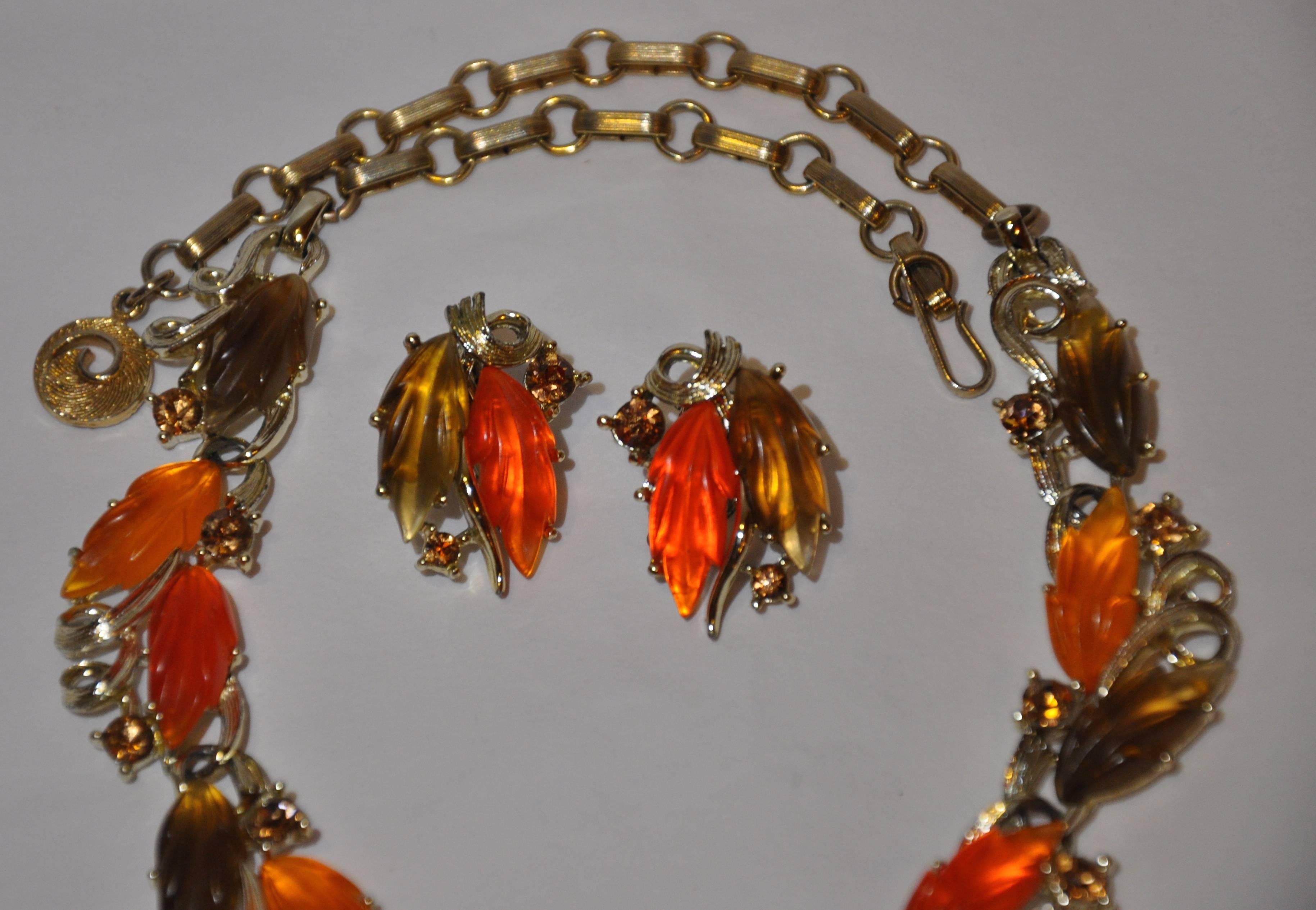        Rara collana Lisner meravigliosamente dettagliata con orecchini a clip abbinati, composta da hardware in oro dorato accentuato da toni di arancio, mandarino e bachelite smerigliata marrone e rifinita con strass. La collana è regolabile e