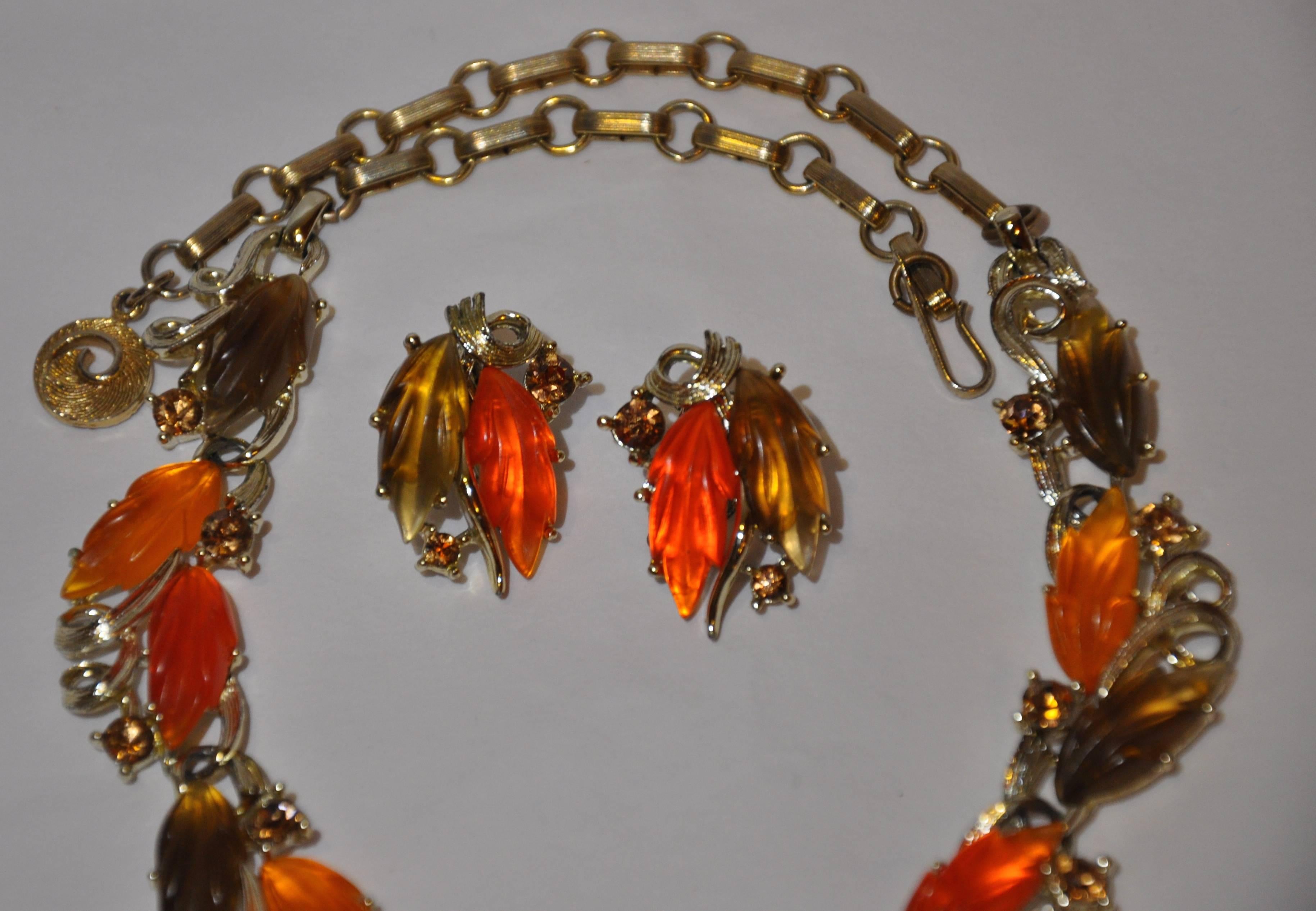        Rare Lisner wonderfully detailed necklace with matching clip-on earrings consist of gilded gold hardware accented with tones of orange, tangerine and brown frosted bakelite and finished with rhinestones. The necklace is adjustable and