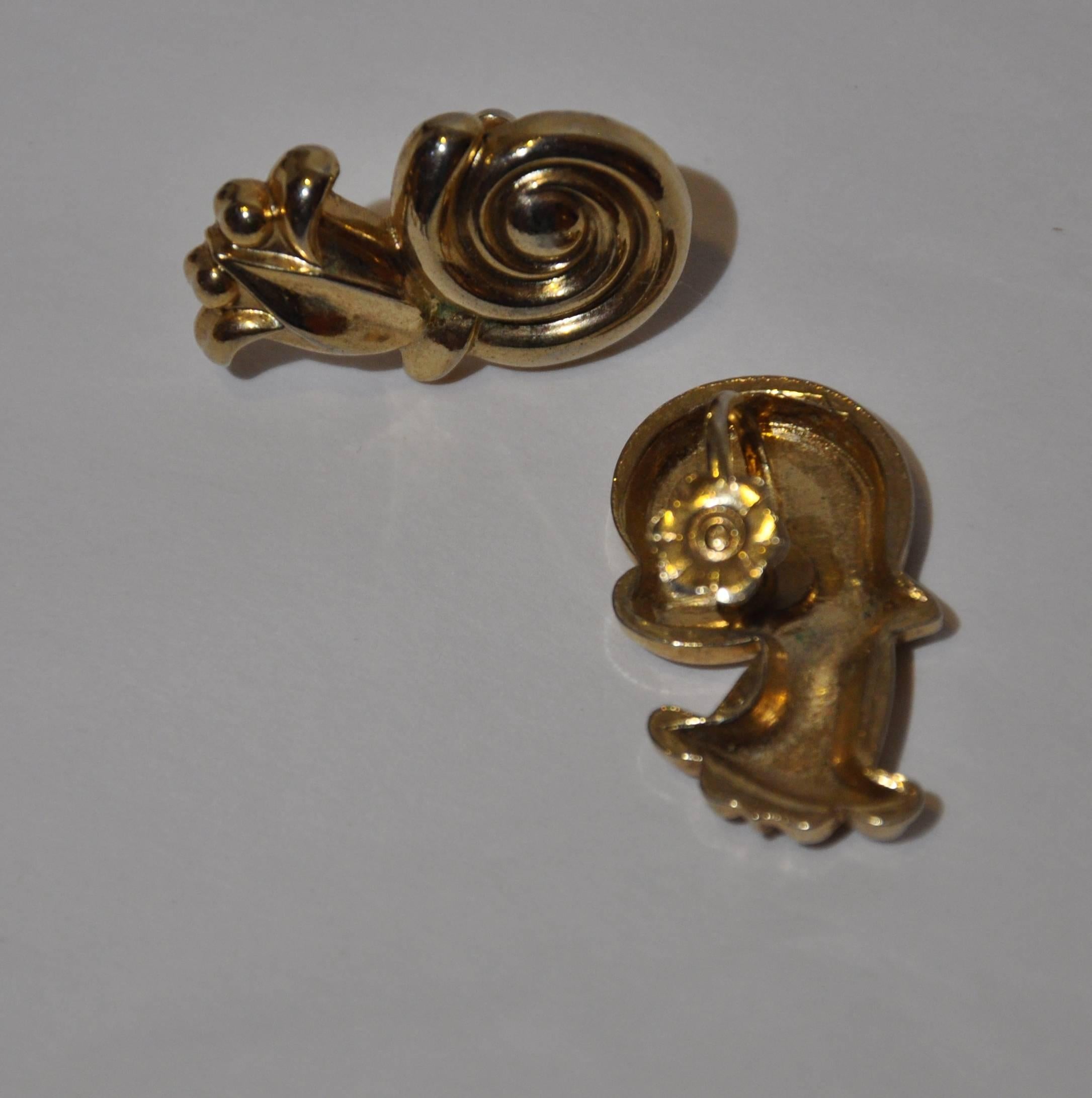      This thick gilded gold tone hardware with vermeil finished "Swirl" screw-one back earrings measures 1 1/8" in height, and 5/8" in width across. The screw on back is detailed as well with a floral etching.