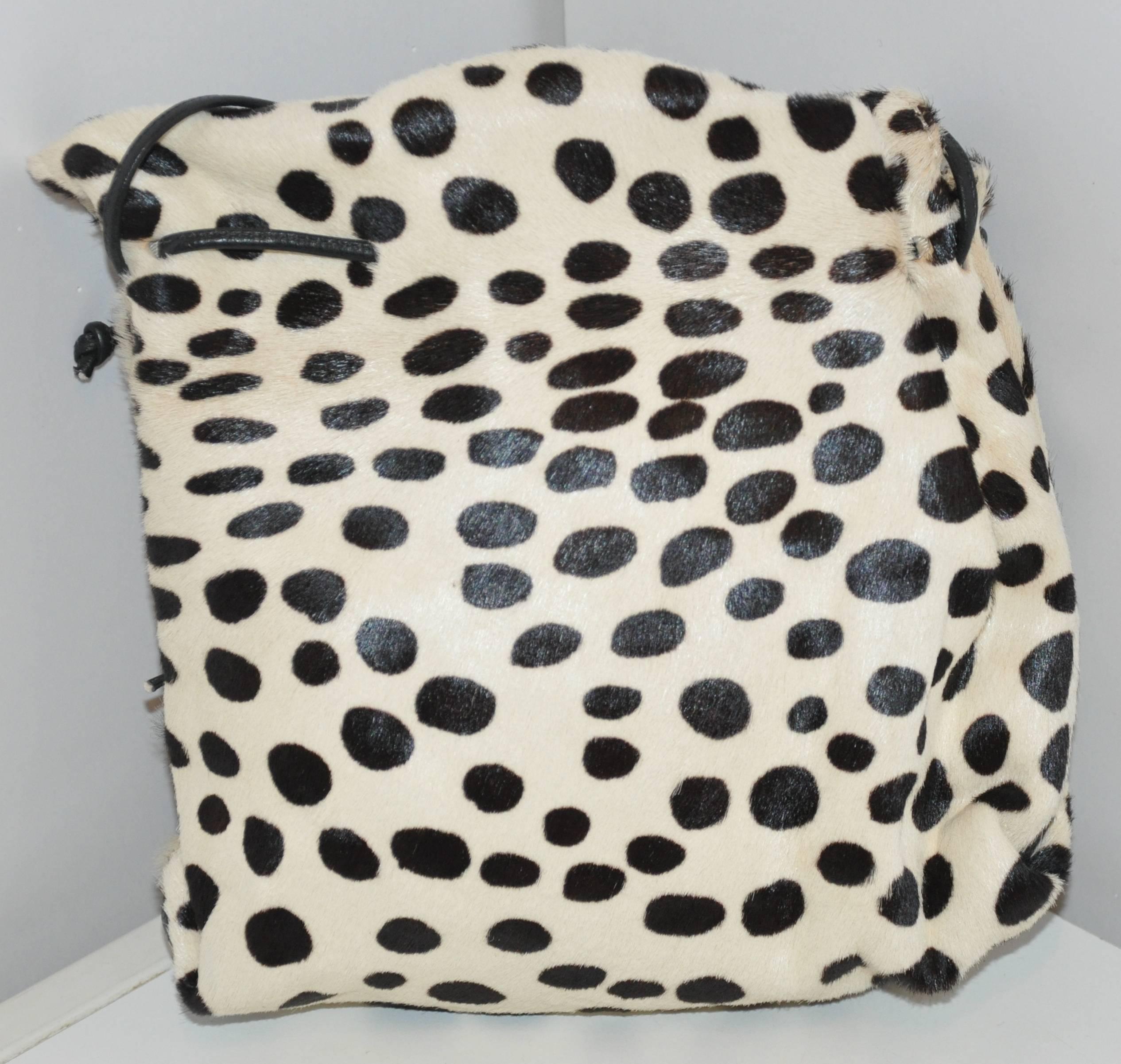         Maravilloso bolso bandolera de piel sintética en color crema y negro de Carlos Falchi, con forro de seda en color crema y compartimento con cremallera. Las esquinas exteriores están acentuadas con botones redondos de cocodrilo negro en