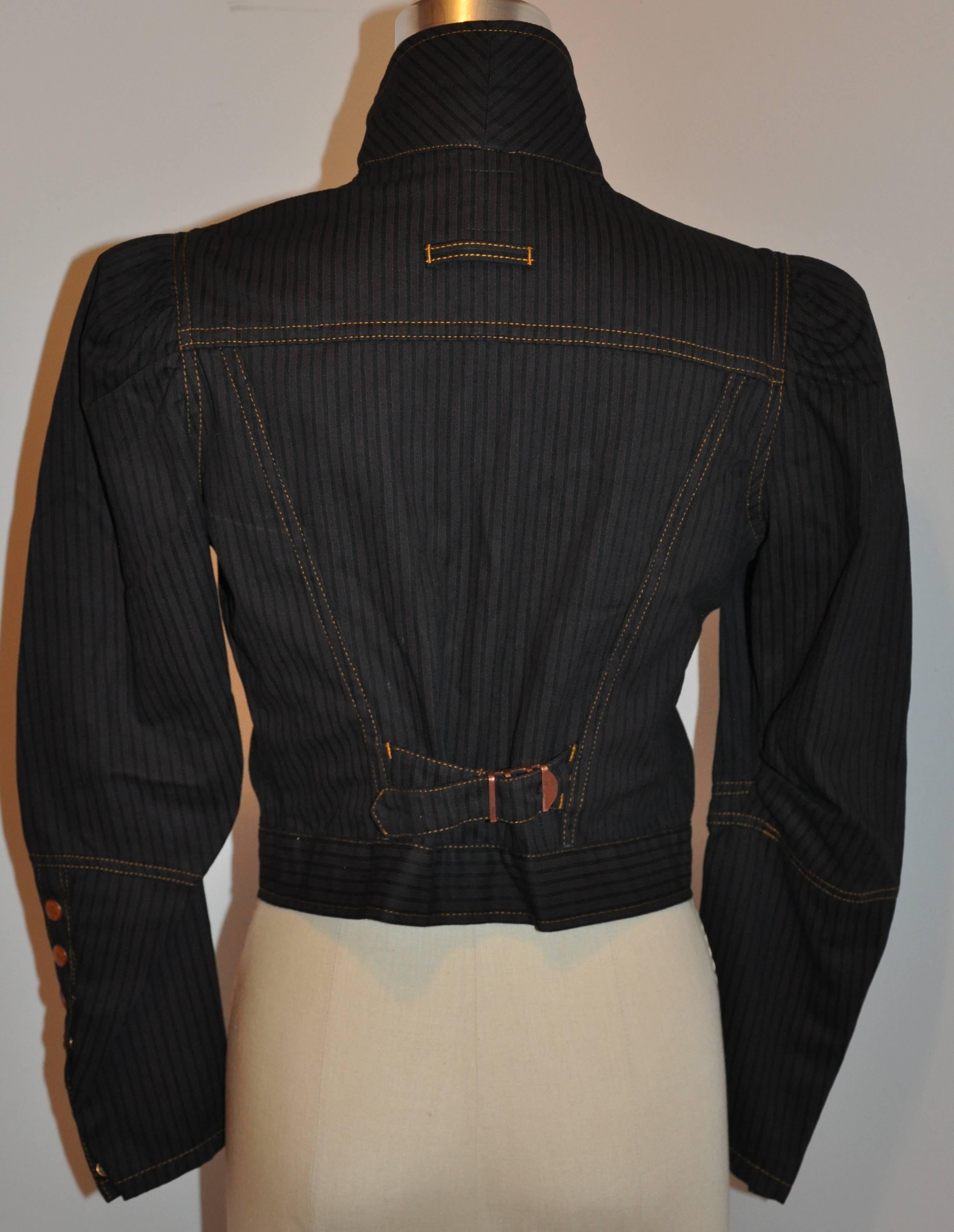        Jean Paul Gaultier cropped jacket is accented with detailed tapered sleeves accented with snaps at the cuffs and puffed shoulders. The center back has adjustable pulls to tighten if desire. There are two patch breast pockets with snap flaps.