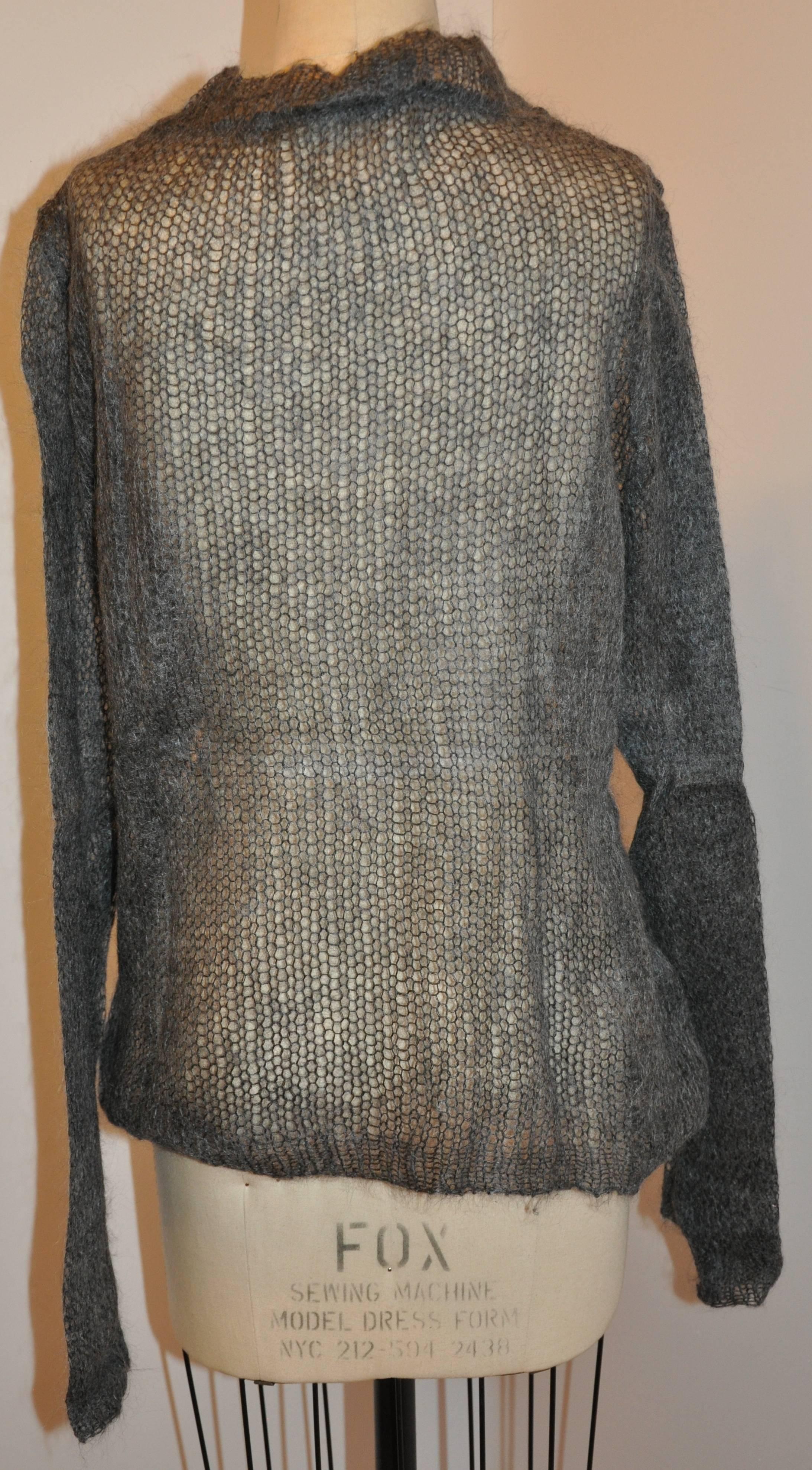        As only Ann Demeulemeester can, this loose-knit charcoal gray crew-neck pullover is made from a blend of 67% wool mohair, 30% nylon and 3% wool giving it a soft-feeling touch. The total length measures 27