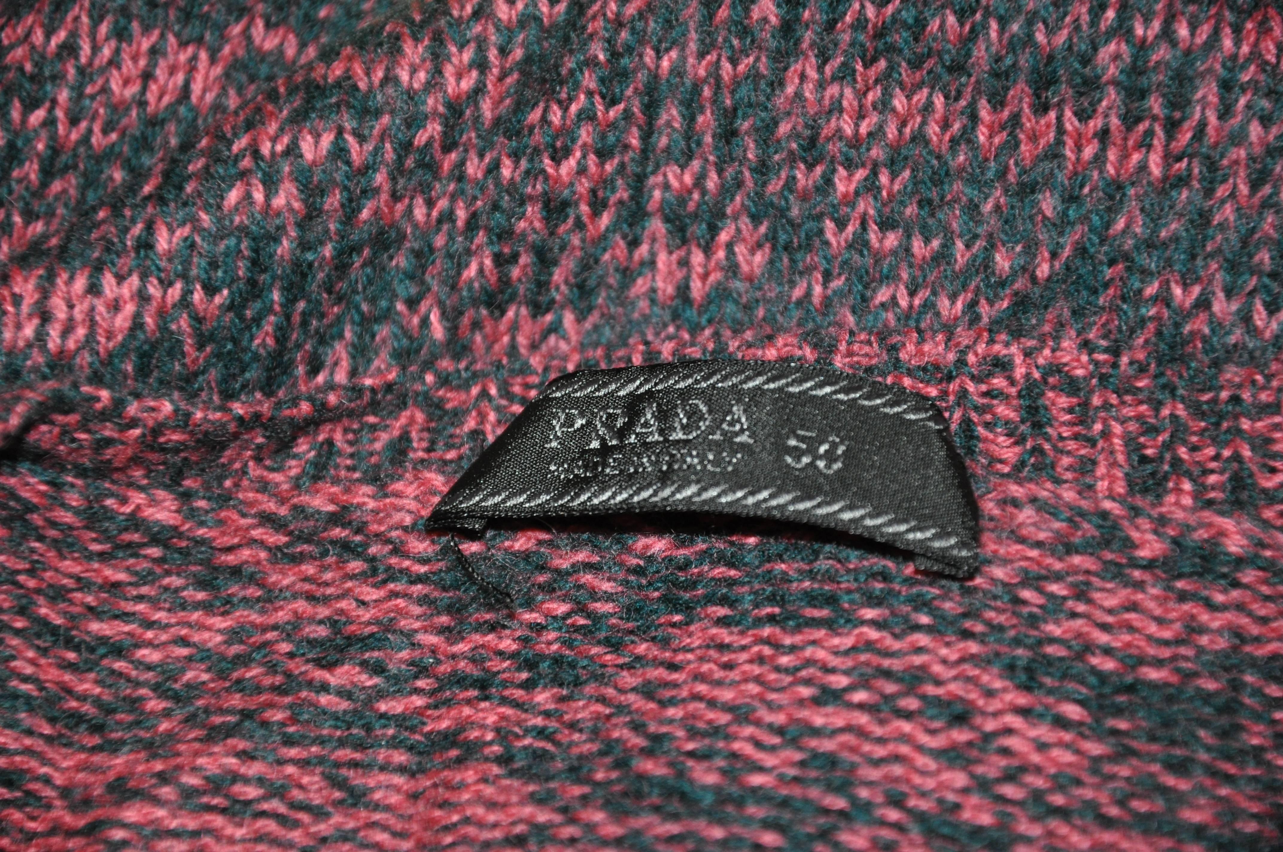        Le pull-over Prada en cachemire merveilleusement doux, à col en V sur le devant, dans un mélange de corail et de marine, mesure 26