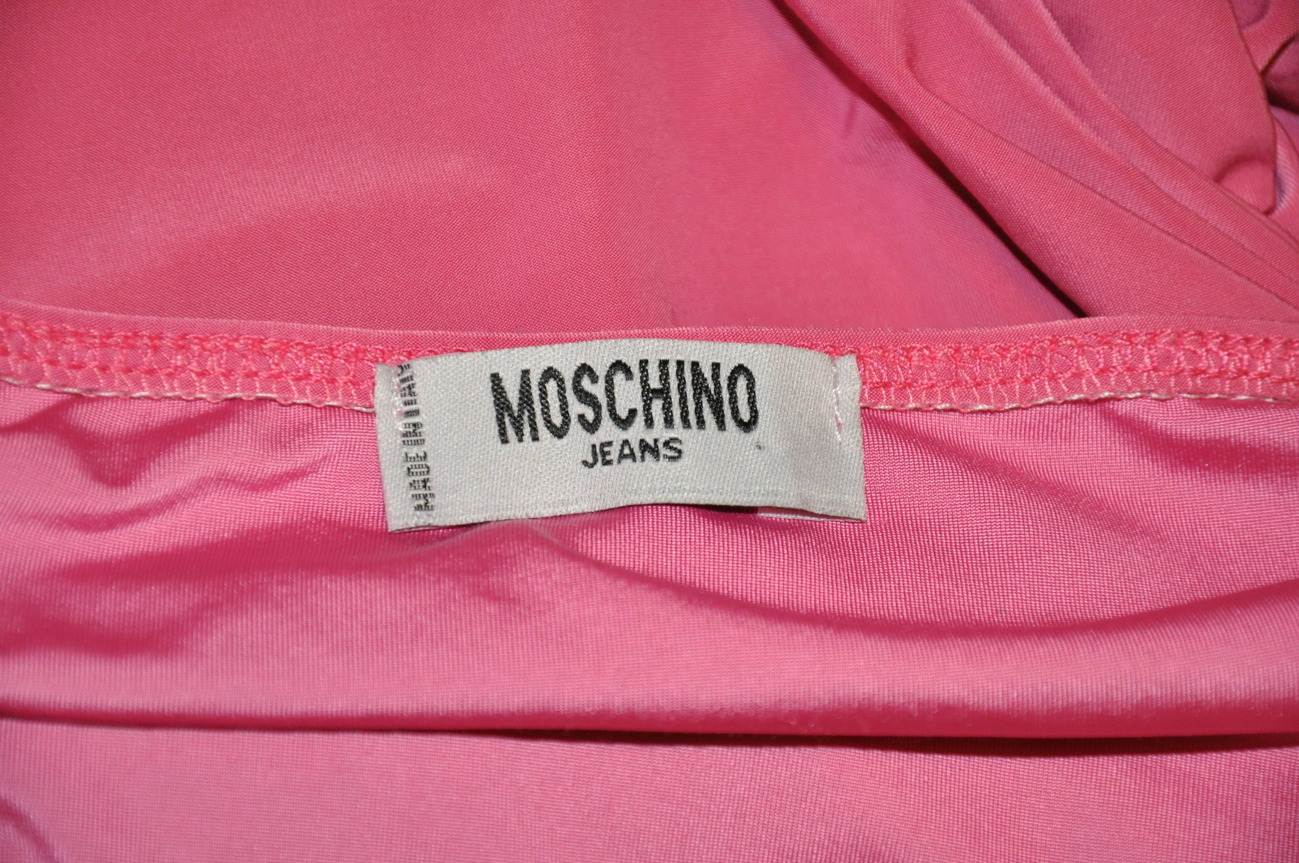        Moschino body-hugging dress in soft fuchsia is accented with detailed sequins. Made of a blend of spandex, acetate and polyester, the length measures 23