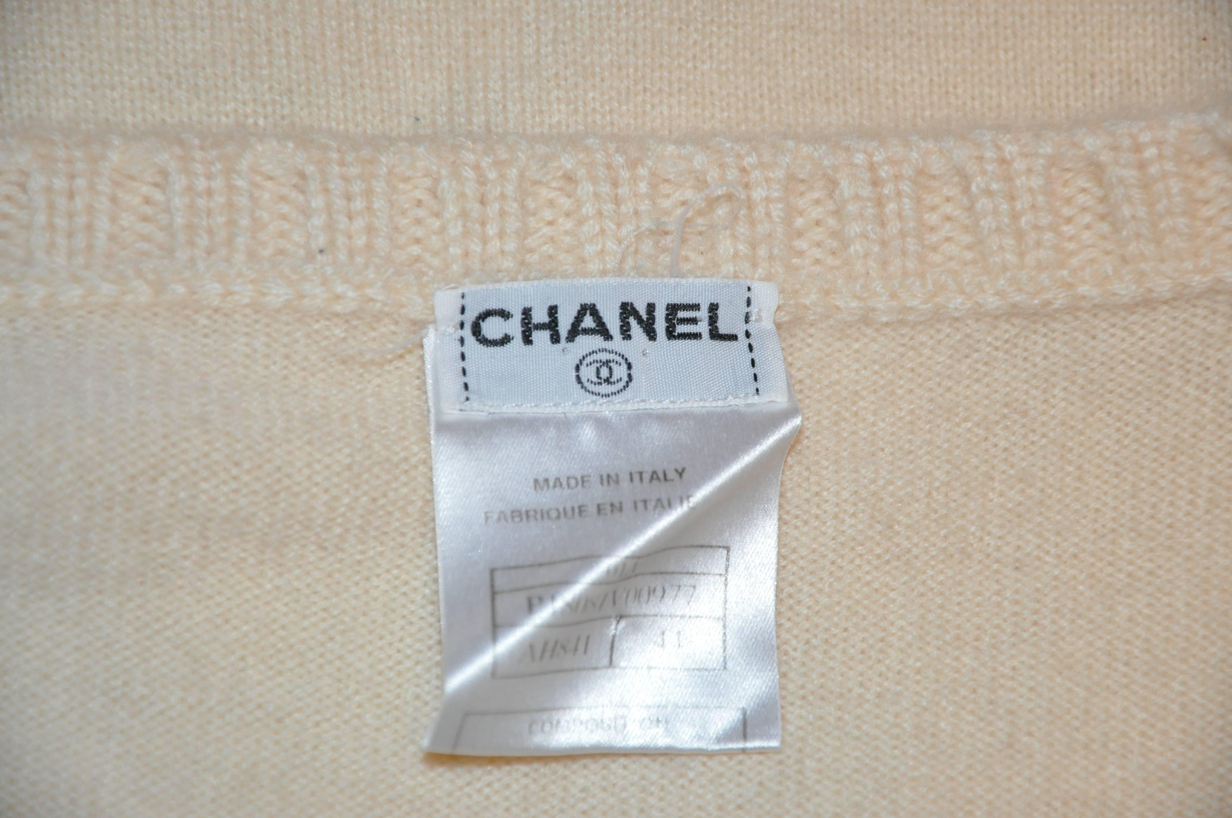        Chanel wonderfully timeless and elegant cream 2-ply cashmere crew neck pullover is accented with their signature name engraved on a 