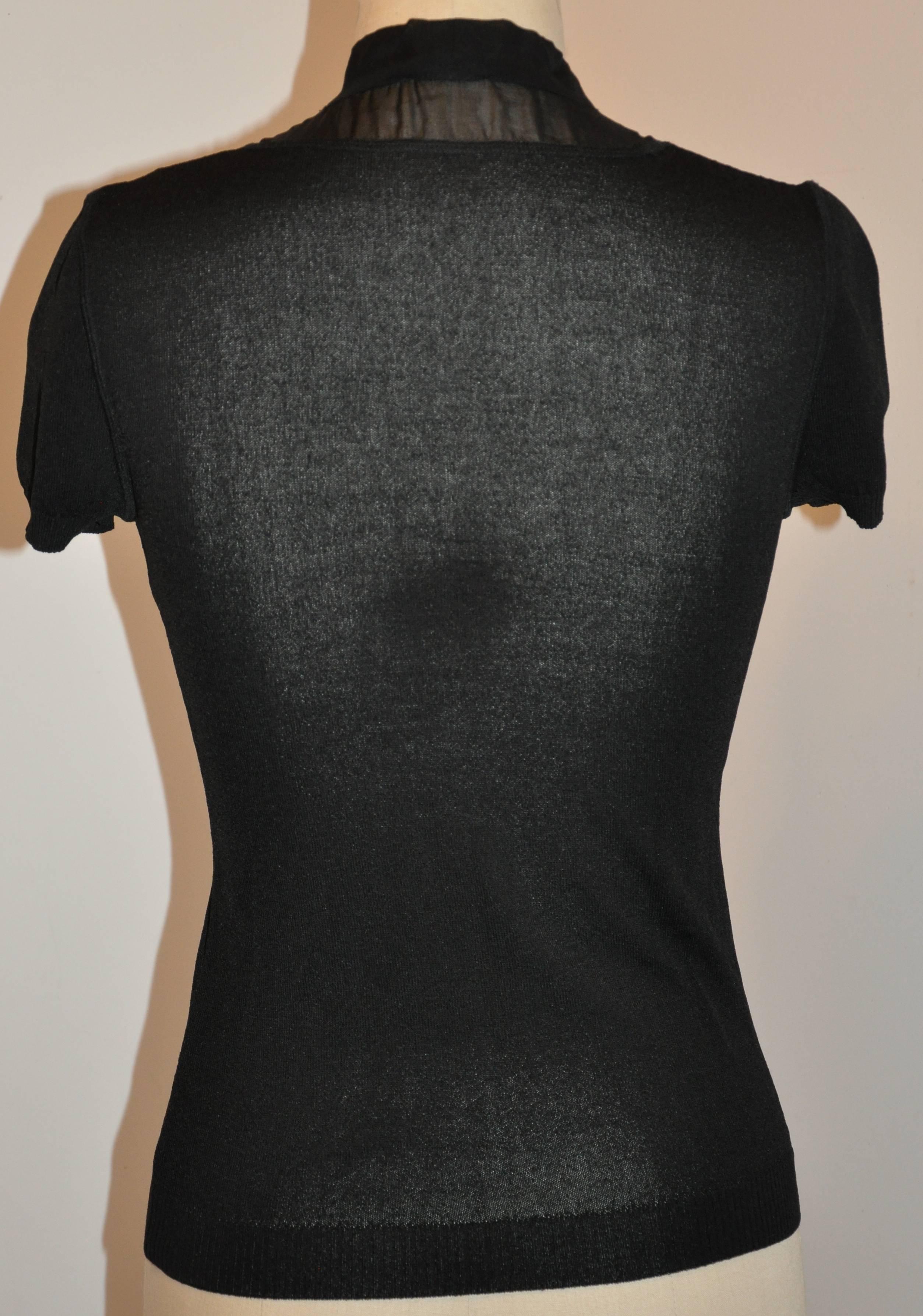        Valentino wonderful craftsmanship in this simply elegant black crew-neck pullover is accented with black silk chiffon open-neck tie collar which can be worn either open or closed and tied into a elegant bow in front.
       The front length