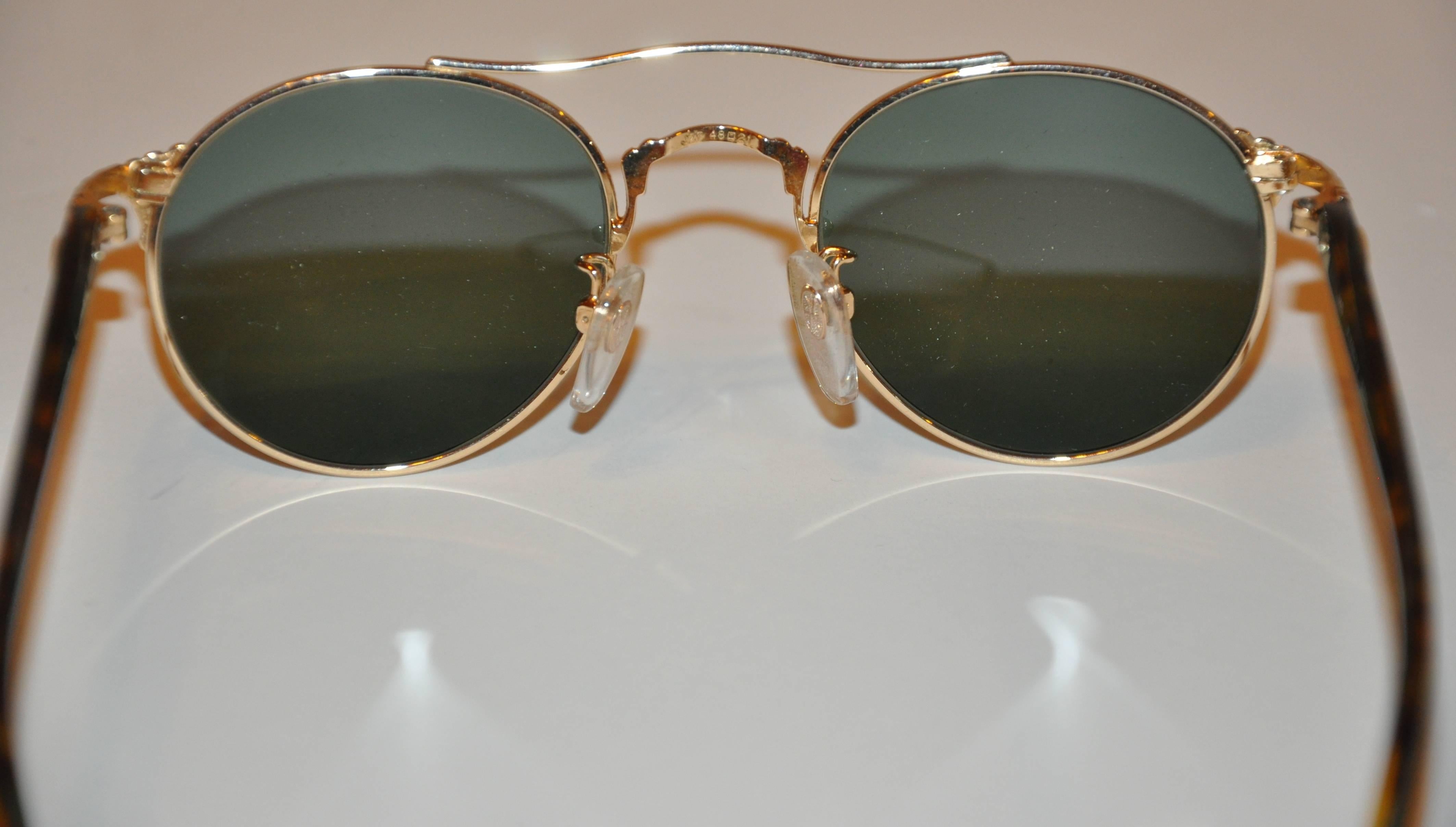        Kansai Yamamoto wonderfully detailed gilded gold hardware sunglasses are accented with etched hardware along the front as well as the arm's corners. The arms are accented with tortoise shell near the ends for better comfort. The width across