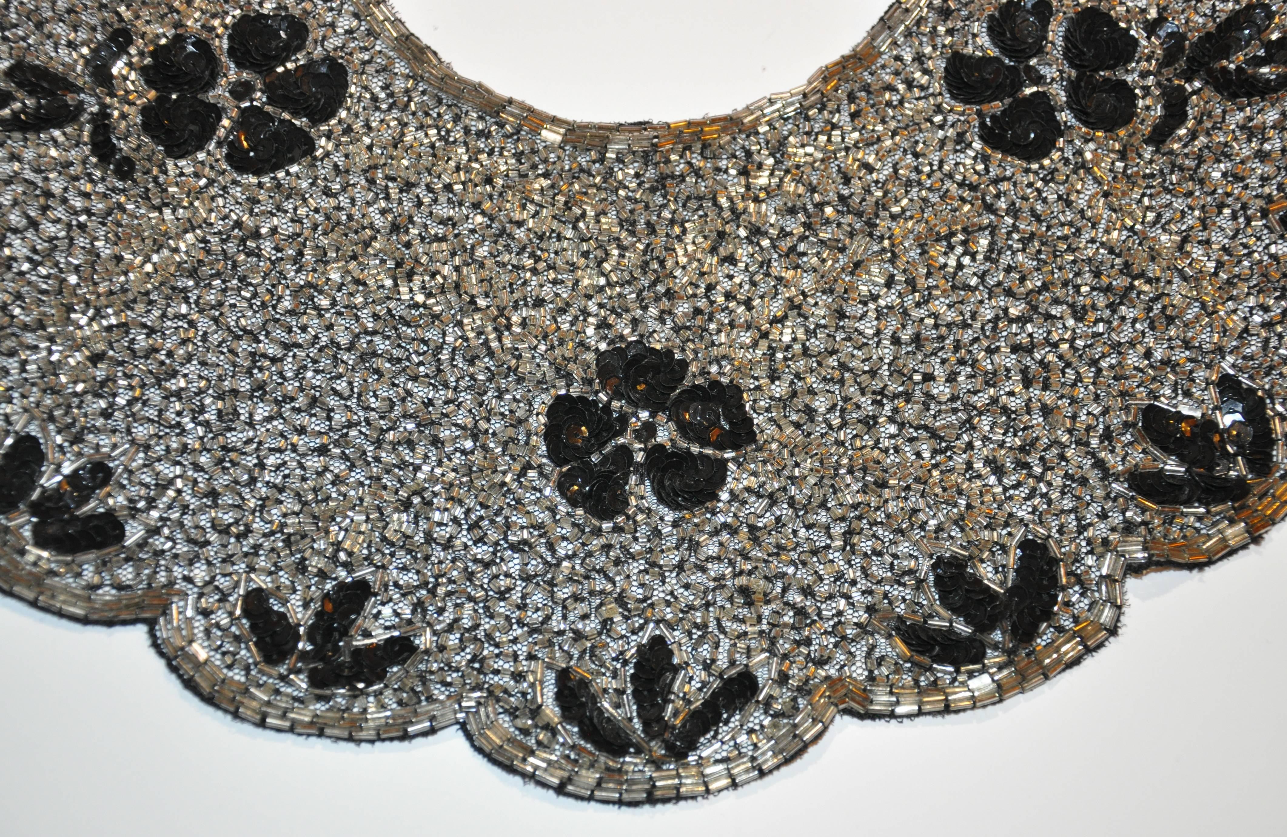        Der wunderschöne schwarze Seidenchiffon-Abendkragen von Mary McFadden ist mit handgefertigter Perlenstickerei verziert, die mit schwarzen Mikro-Pailletten für das florale Design akzentuiert ist. Der innere Kragen misst 15