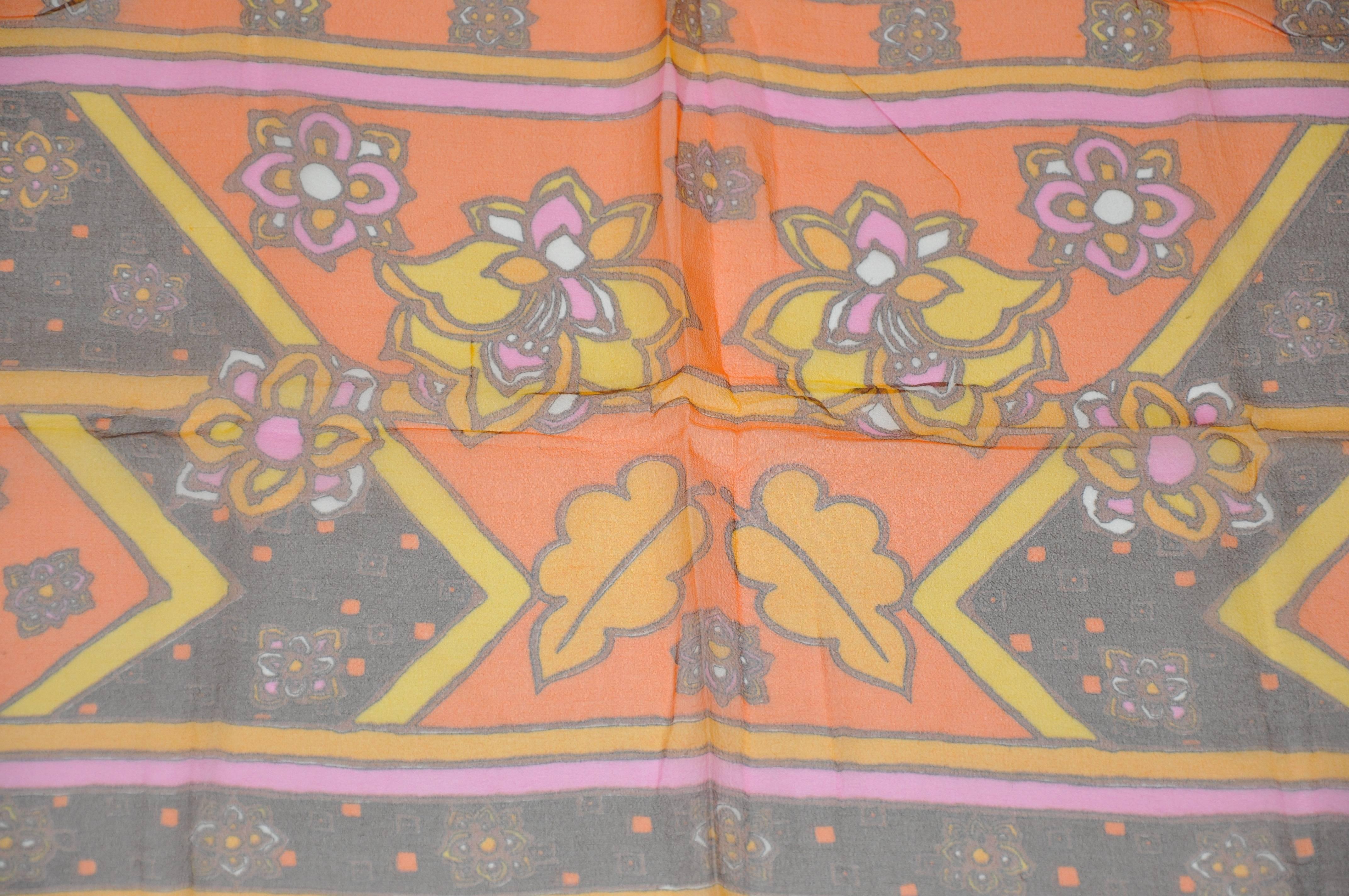 Bordes de color mandarina acentuados con un pañuelo rectangular central floral que mide 15