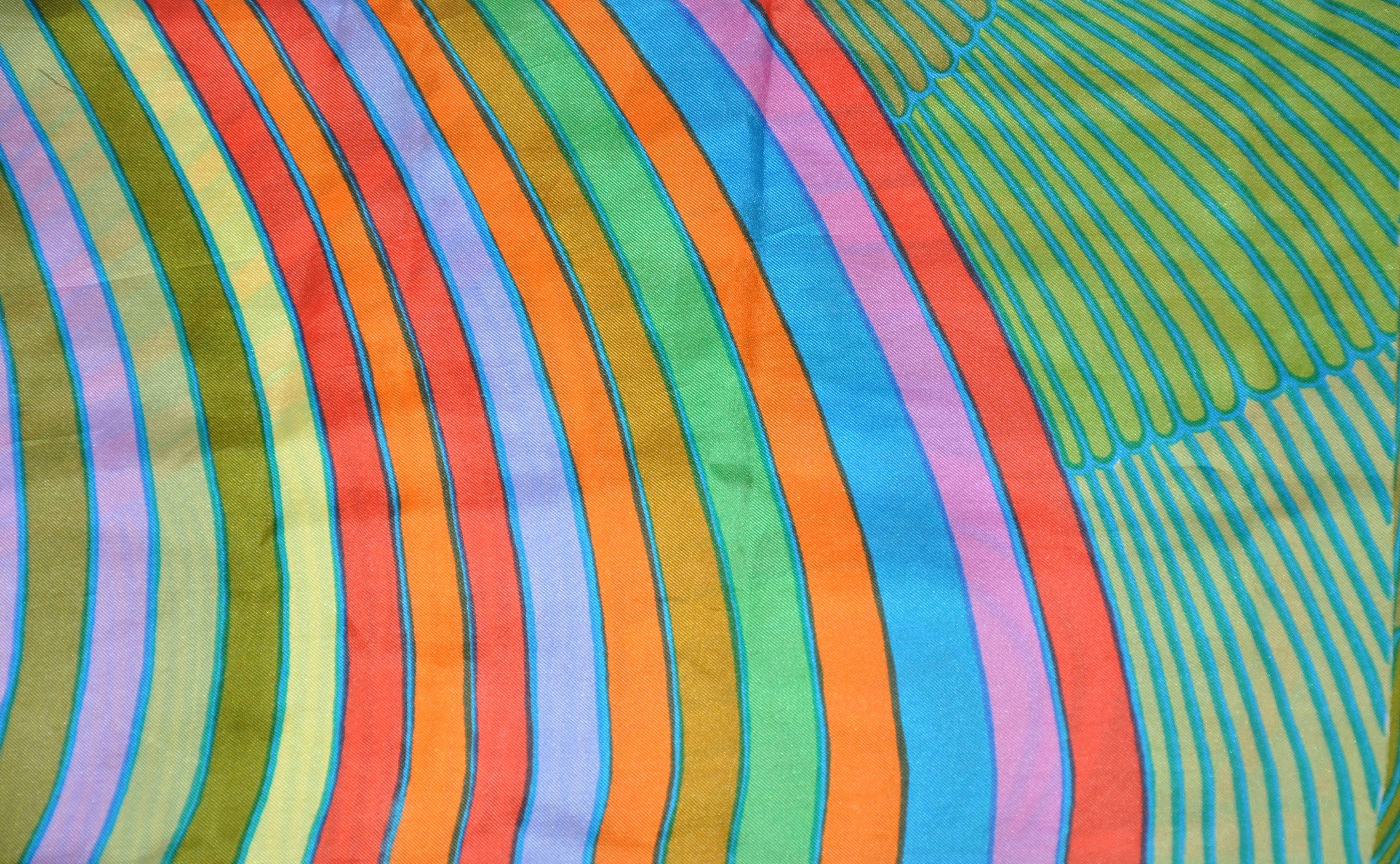 This wonderful and colorful double-layered "Colors of the Rainbow" is accented with fringed edges, and measures 9 1/2" x 42". Made in the USA.