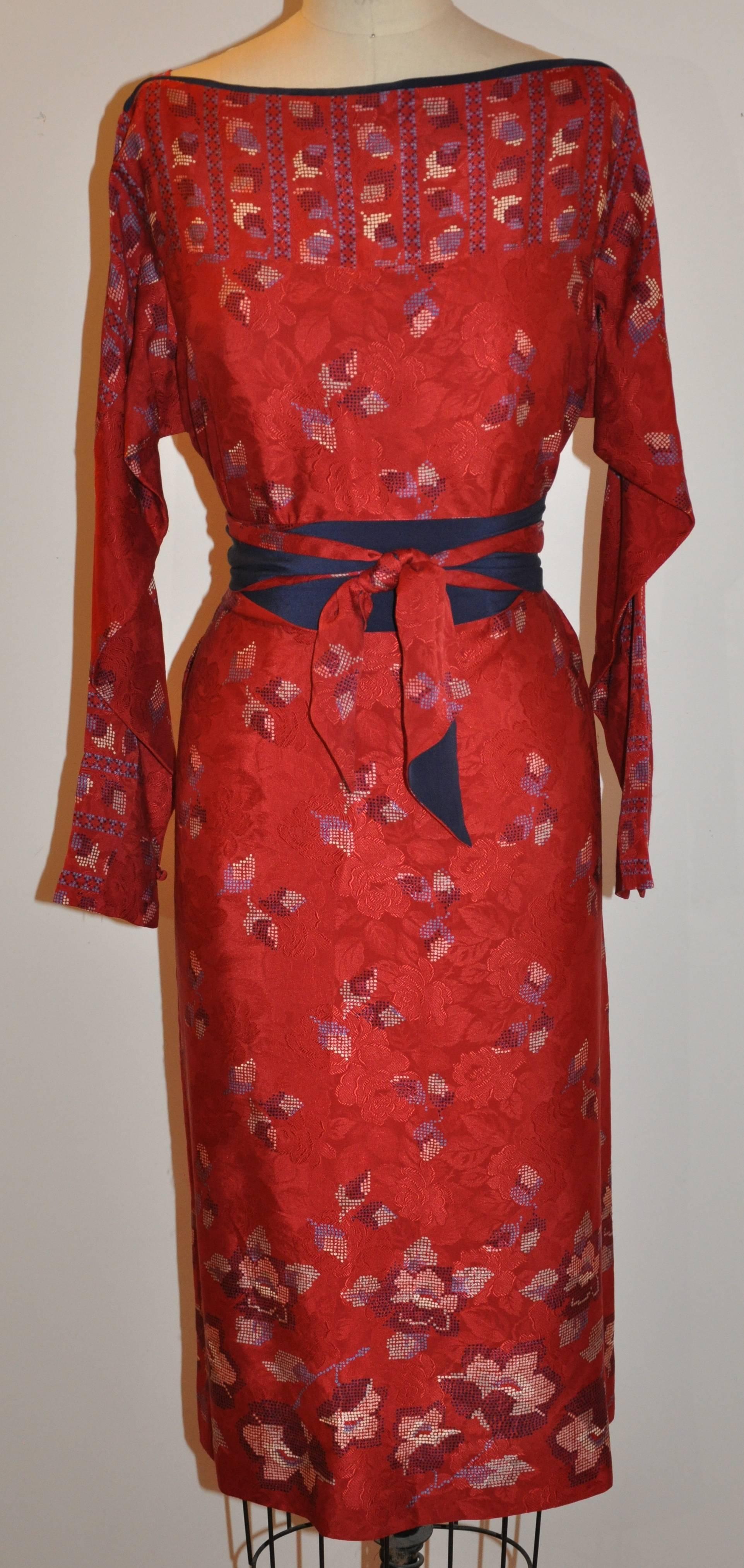    The iconic Halston's wonderful silk floral boat-neck sheath has multi-colors of bursting florals over a red-on-red roses print underneath. The matching self-tie belt measures 5 inches x 73 inches with one side in navy, giving the option to wear