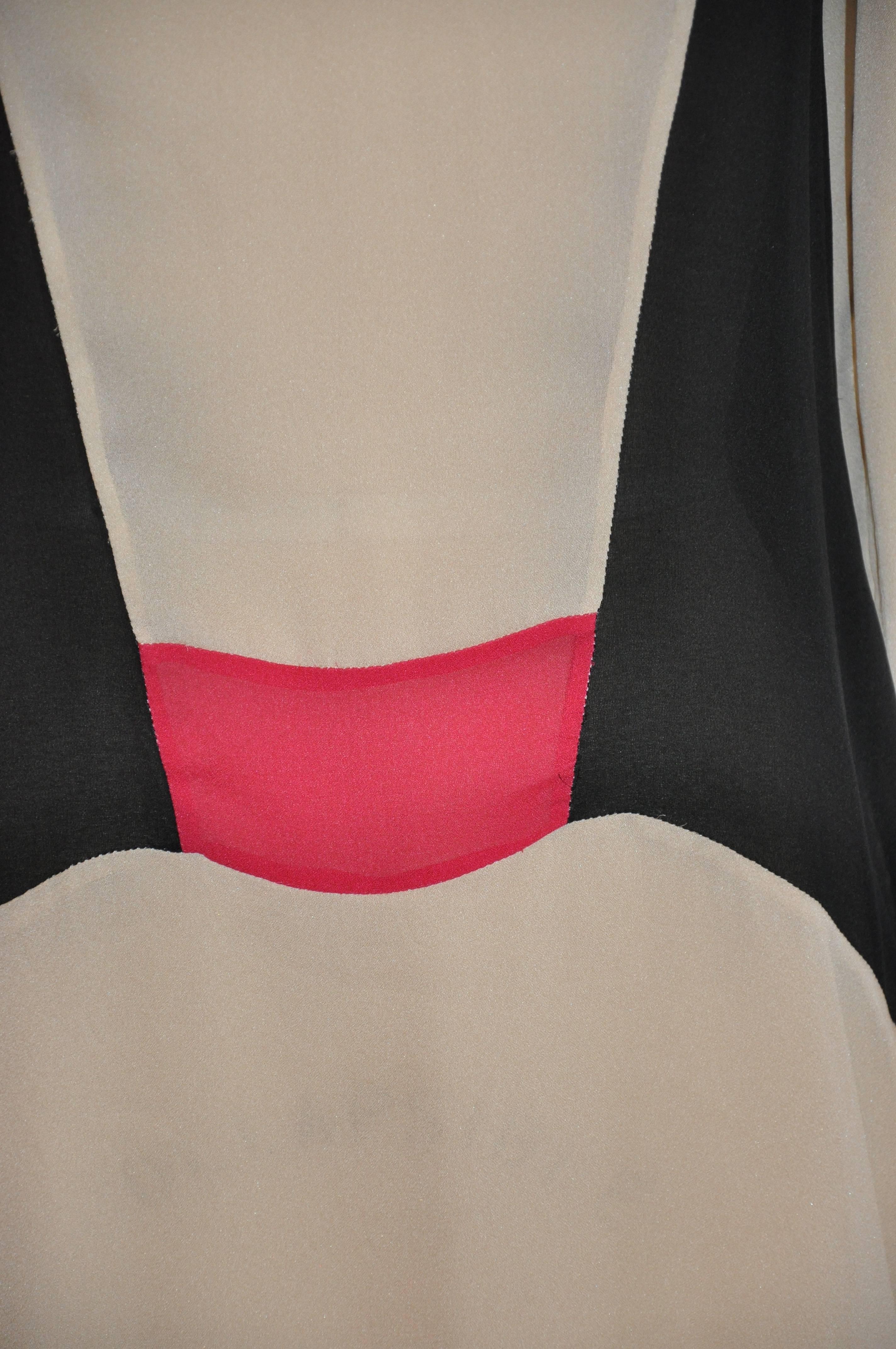       This wonderful ivory tunic is accented with black and highlighted with fuchsia. The interior is detailed with 