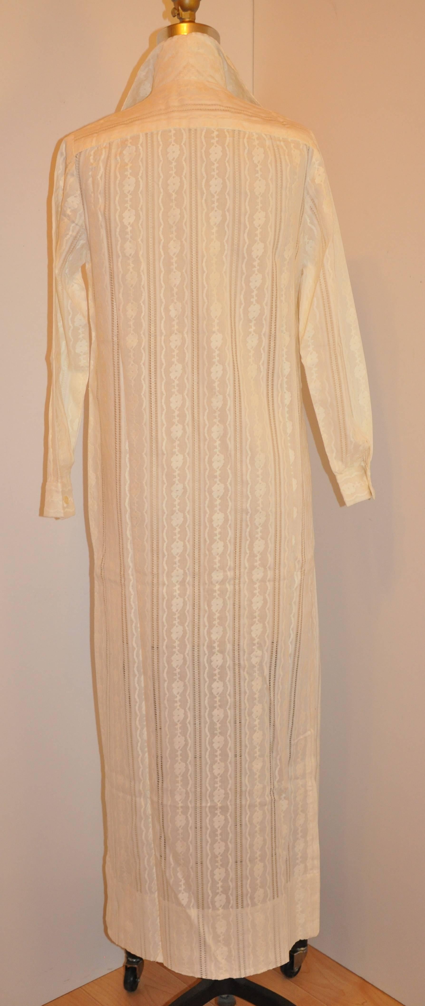        This wonderfully detailed ivory cotton of embroidered & eyelet combination can double as either a maxi dress or as a maxi spring or summer coat. There are two high slits measuring 14 1/2" on both sides. The ten-button front are