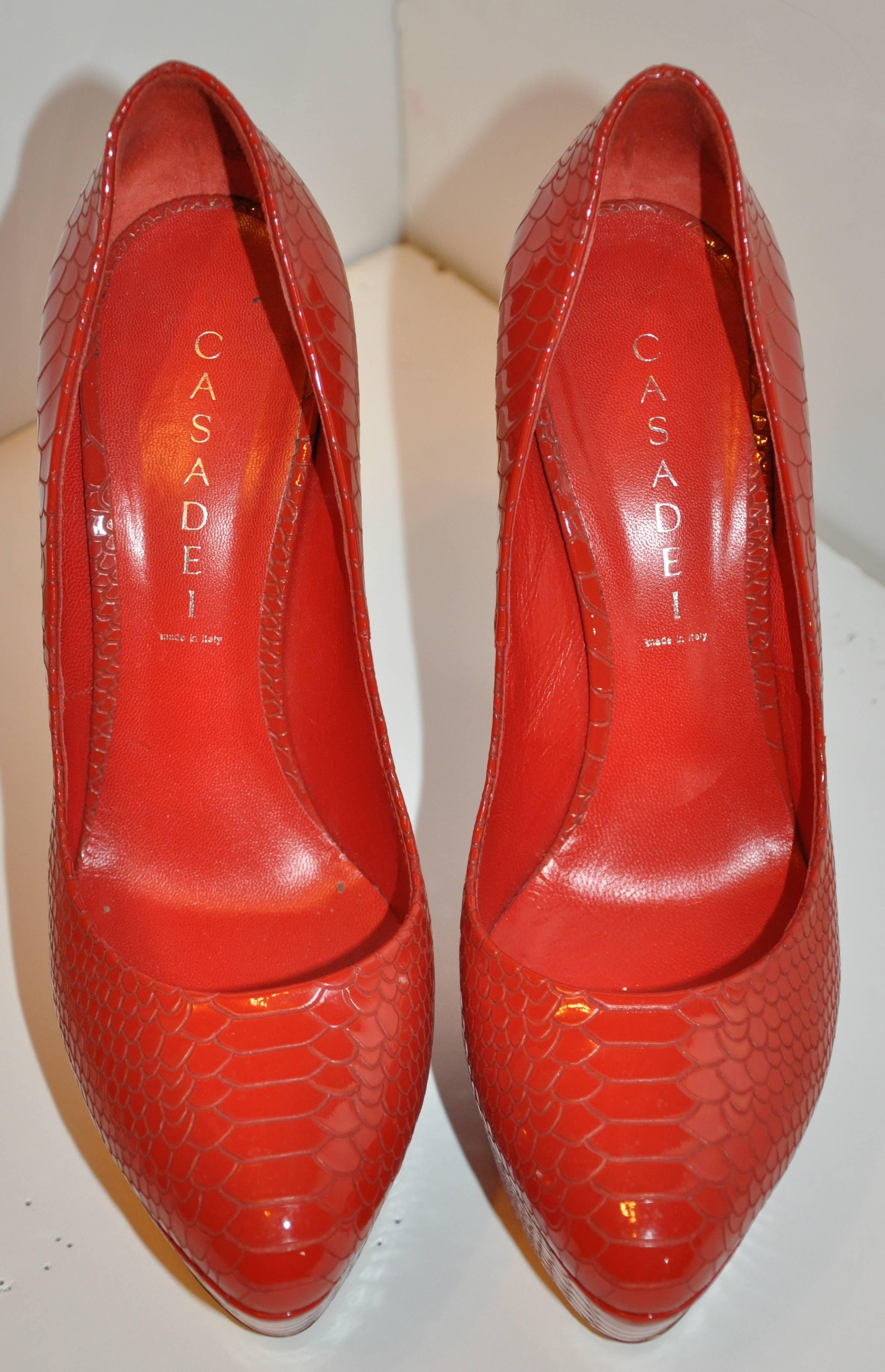      Casadei wonderfully wicked bold fire-engine red embossed lizard patent leather platform pumps are sized 9B,  39/Italy. The back heel measures 6 inches in height, front's height measures 1 1/2 inches. The length from front to back measures 7