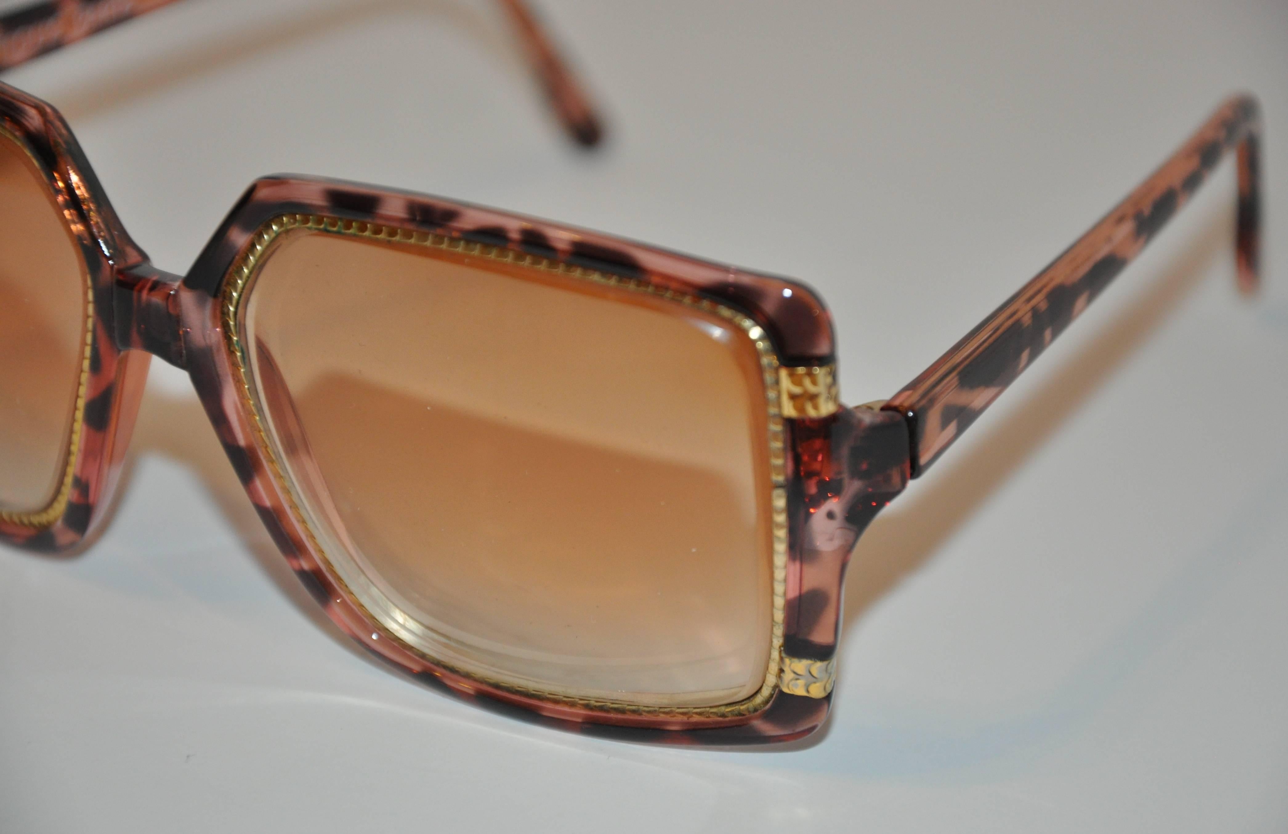        Ted Lapidus wonderfully detailed glasses consist of gilded gold "snake" hardware surrounding the prescription lens and finished with clear tortoise shell lucite throughout. The length across the front measures 5 3/4", height is