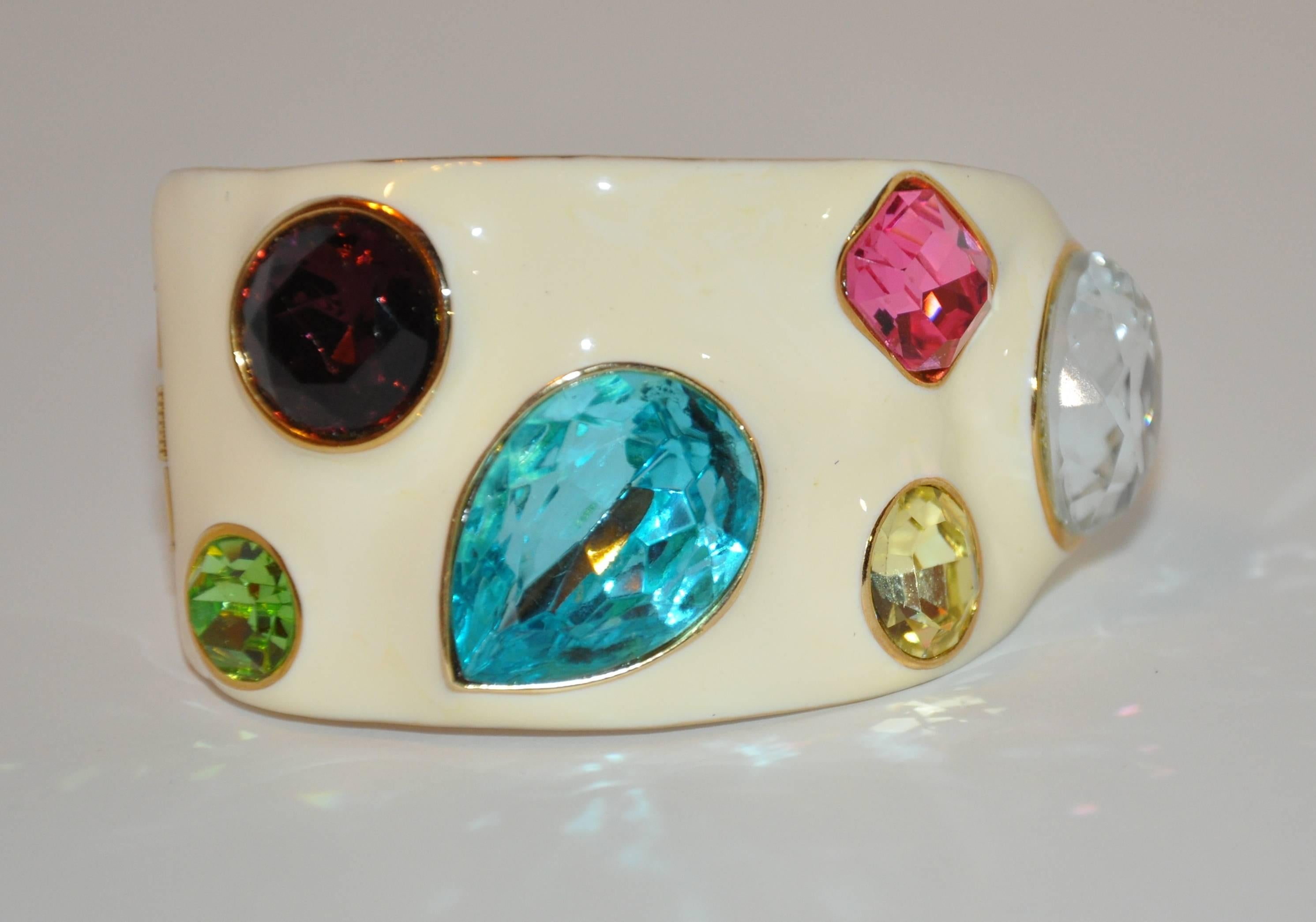      The famed Kenneth Jay Lane, who recently left us, created this wonderful vanilla enamel cuff bracelet accented with multi-size multi-colors encased in gilded gold hardware measures 2 1/2" x 1 5/8". Width is 6/8" - 1 1/2",