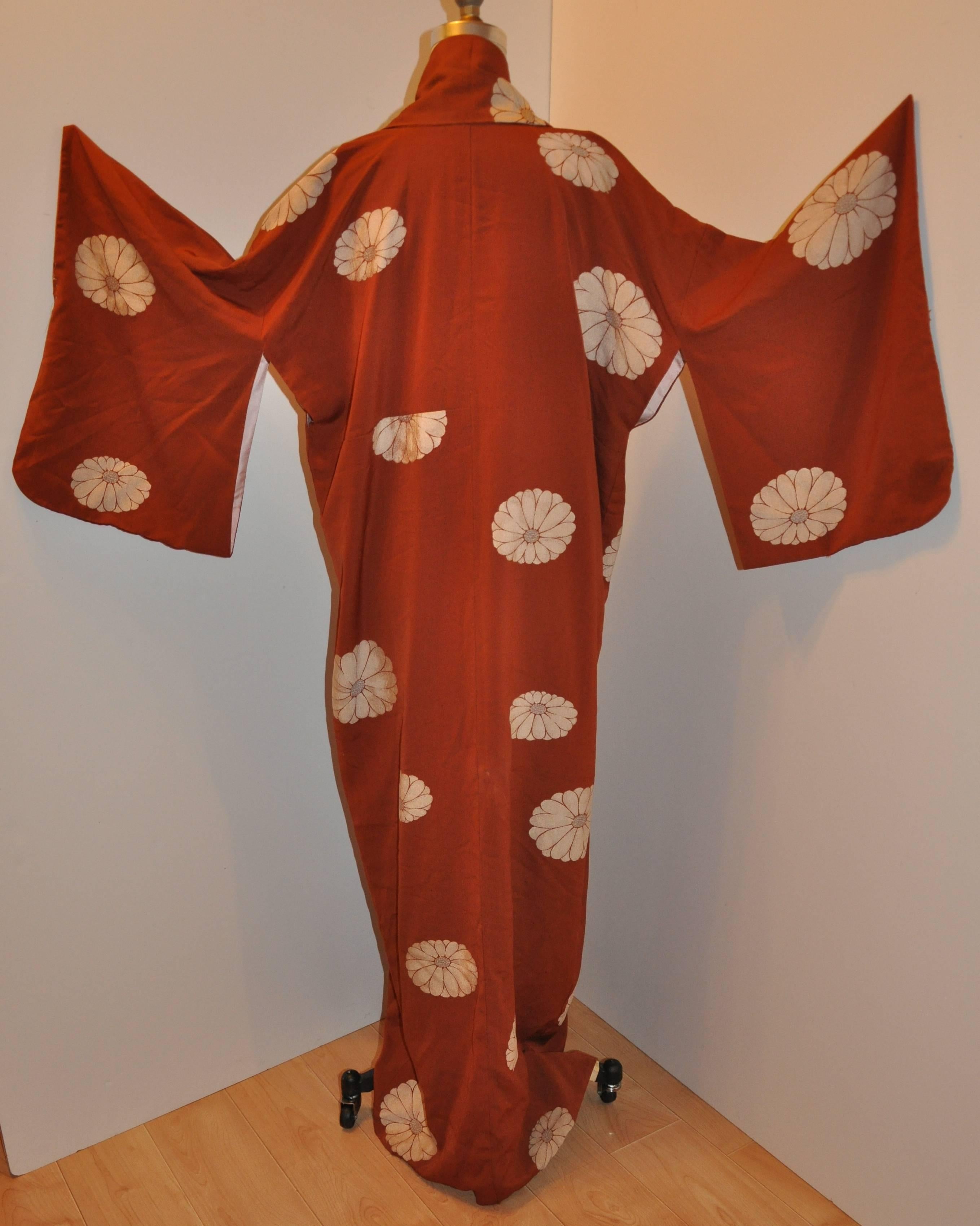        This wonderful warm brown silk kimono has large blooming floral throughout.  The interior is lined with rice-colored silk and measures 61 inches in length. The underarm circumference measures 48 inches, collar width is 4 1/2 inches,