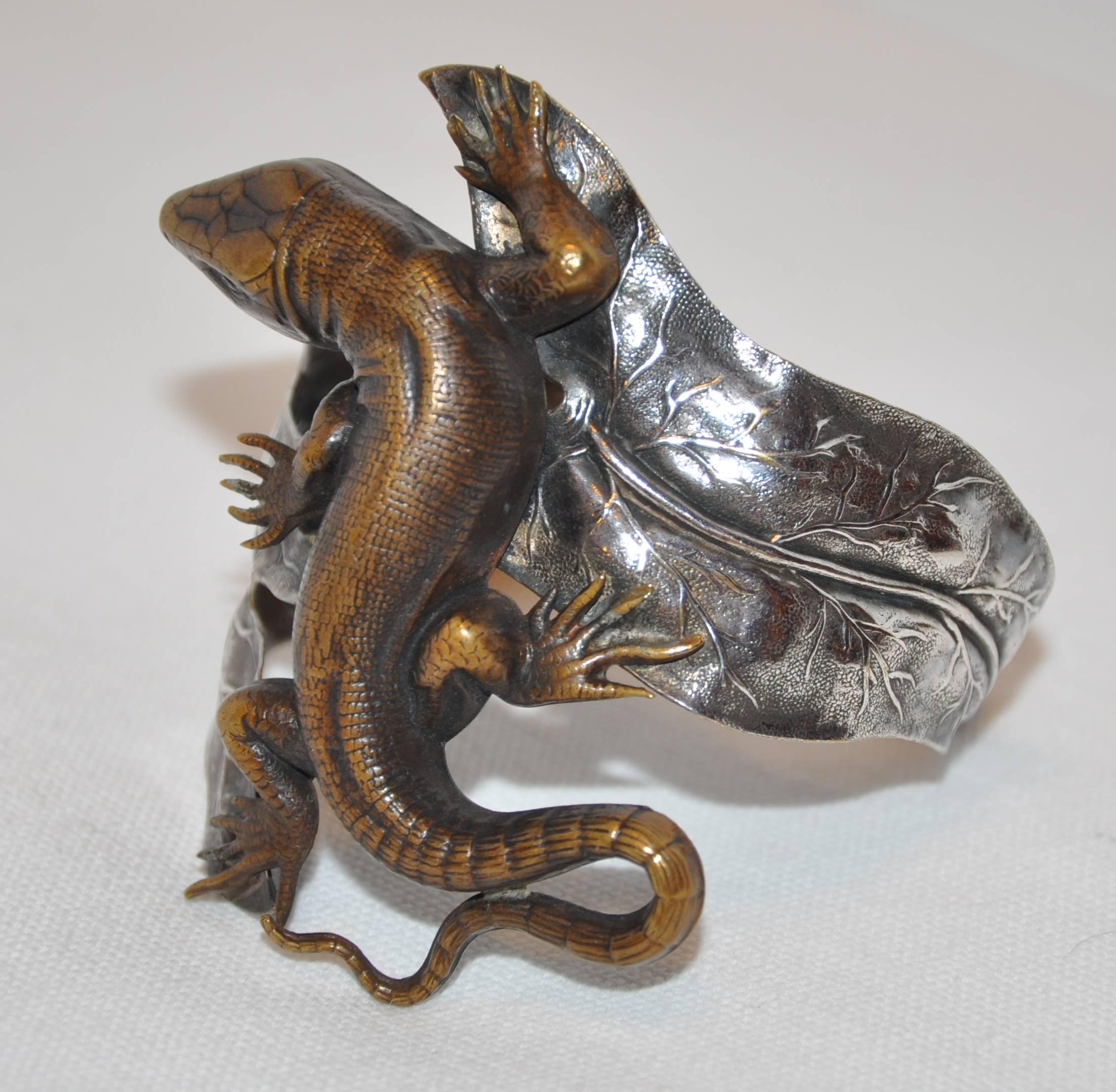        This wonderfully detailed form-fitting adjustable cuff bracelet of a combination of hammered and etched silver is highlighted with a whimsical etched bronze lizard which appears to wrap around the wrist when the adjustable cuff bracelet is