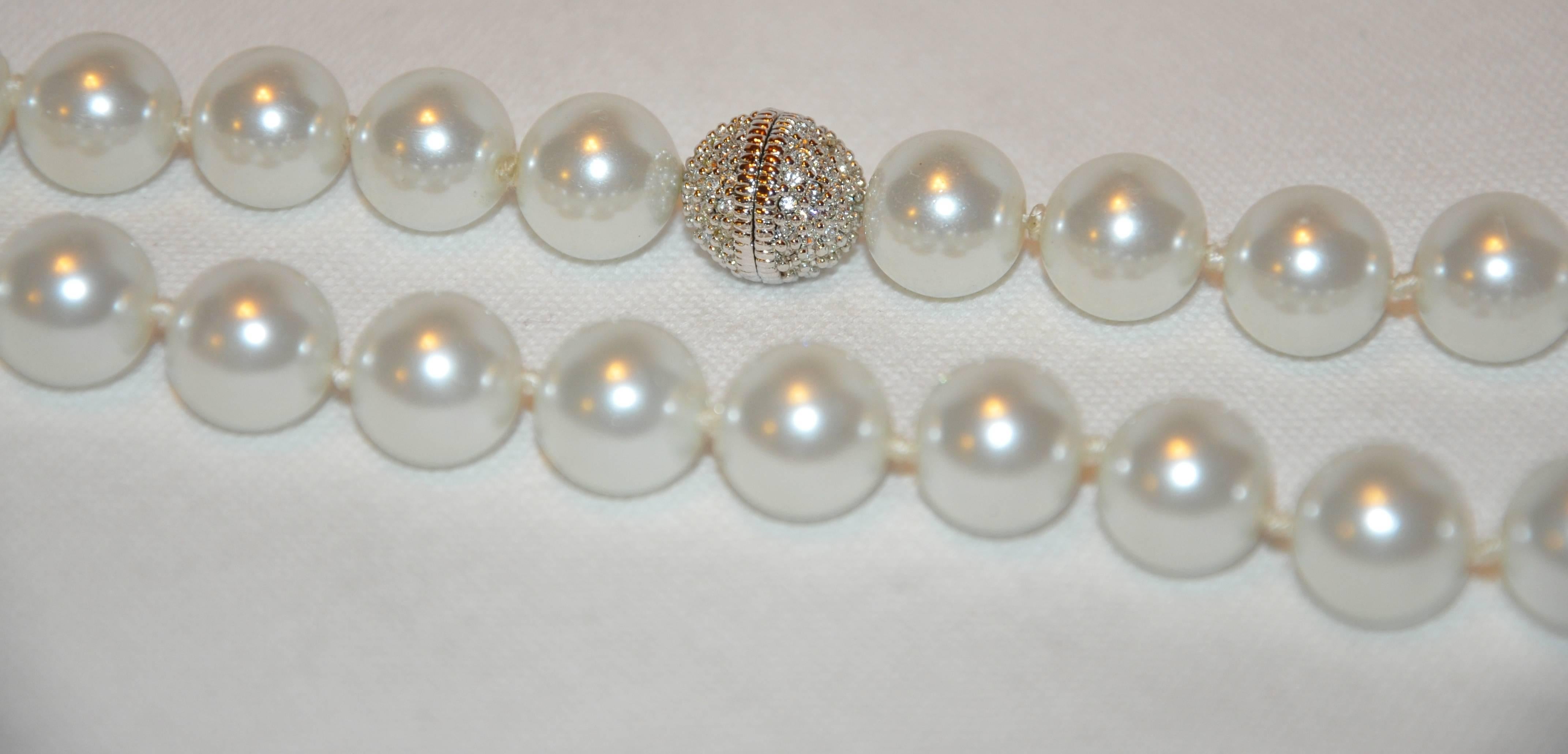         Ce grand collier de fausses perles merveilleusement élégant est agrémenté d'un fermoir à vis orné de strass de la même taille que la fausse perle de 1/2