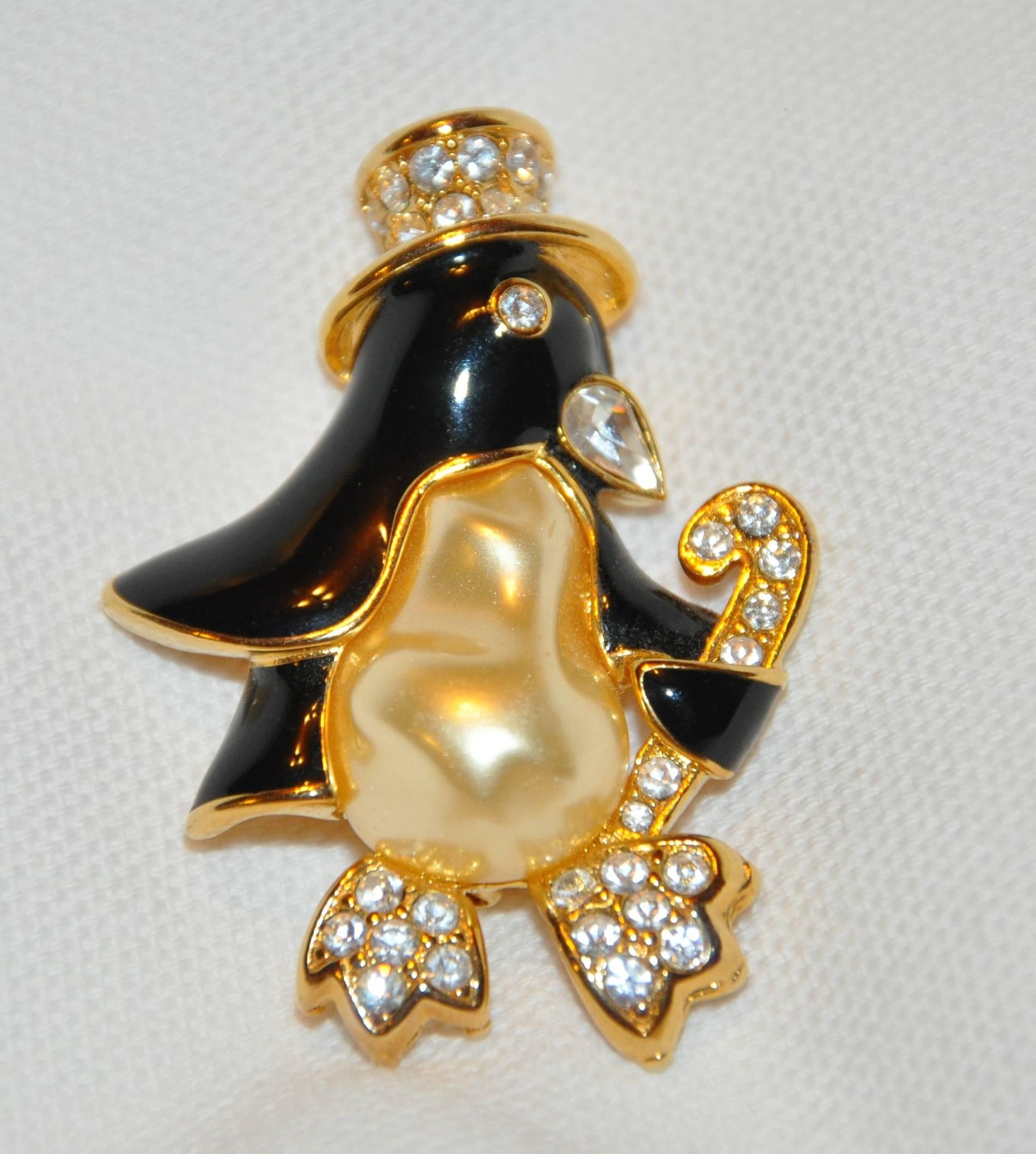        Kenneth Jay Lane's wonderfully whimsical large penguin set in polished gilded gold vermeil hardware with black enamel and highlighted with a large faux pearl and faux diamonds. This wonderful brooch measures 2" x 1 1/4", made in