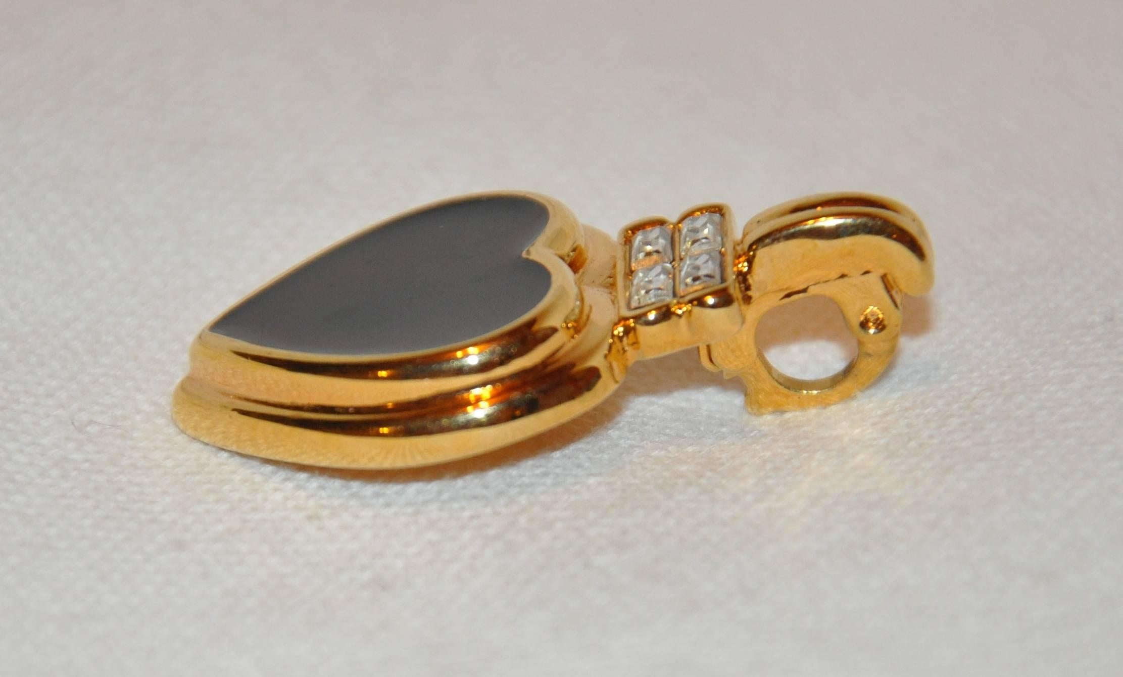        Kenneth Jay Lane gilded gold vermeil hardware accented with black enamel pendant is detailed with a clip-on clasp to use as a pendant, or, if desired, to clip on to a charm bracelet, and measures 1 5/8" x 1". Made in the United