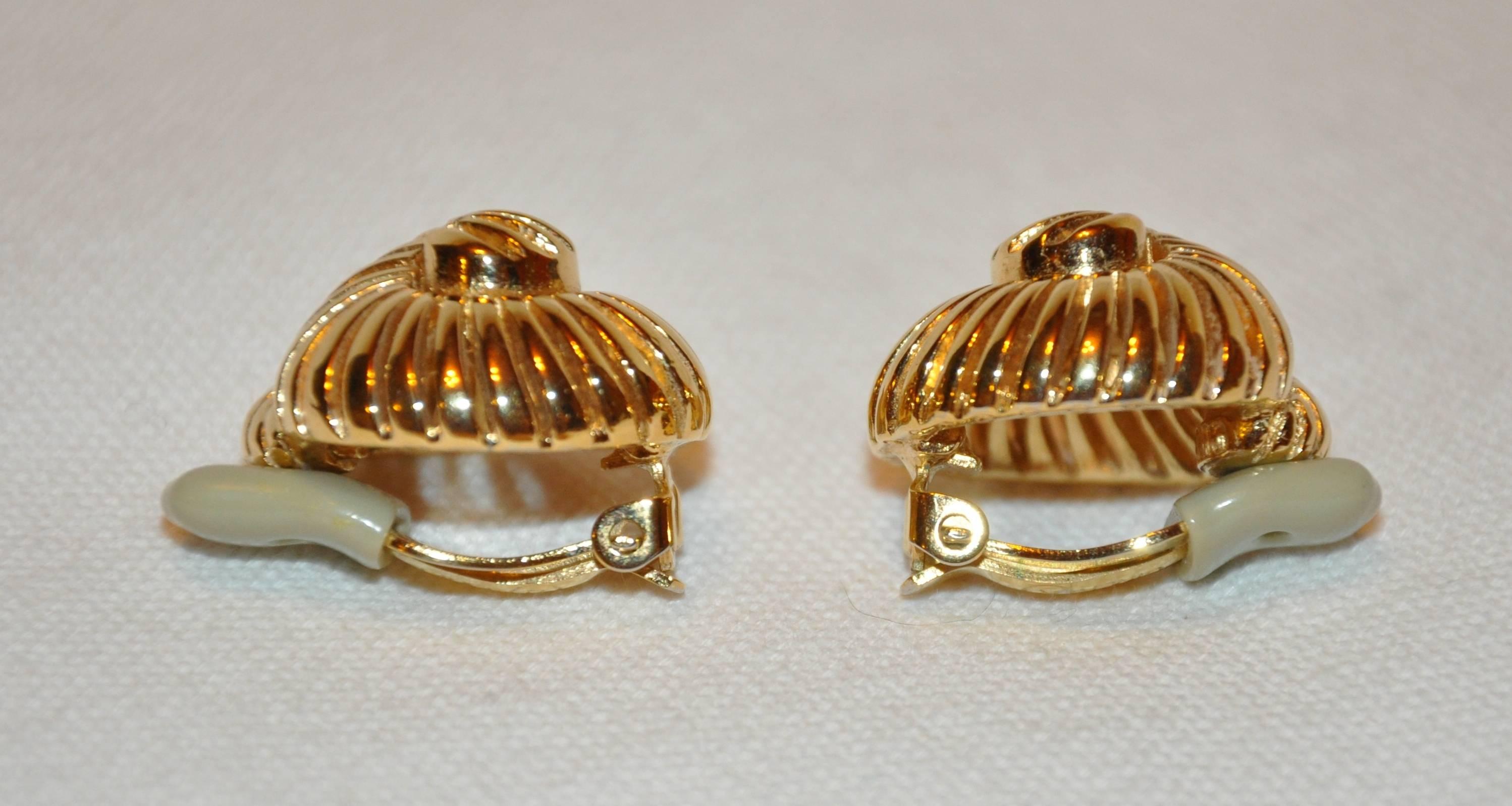        Ciner's wonderful elegant gilded gold vermeil hardware "Seashell" clip-on earrings are timeless and classic. These earrings measures 1" x 1", with a depth of 1/2", made in USA.