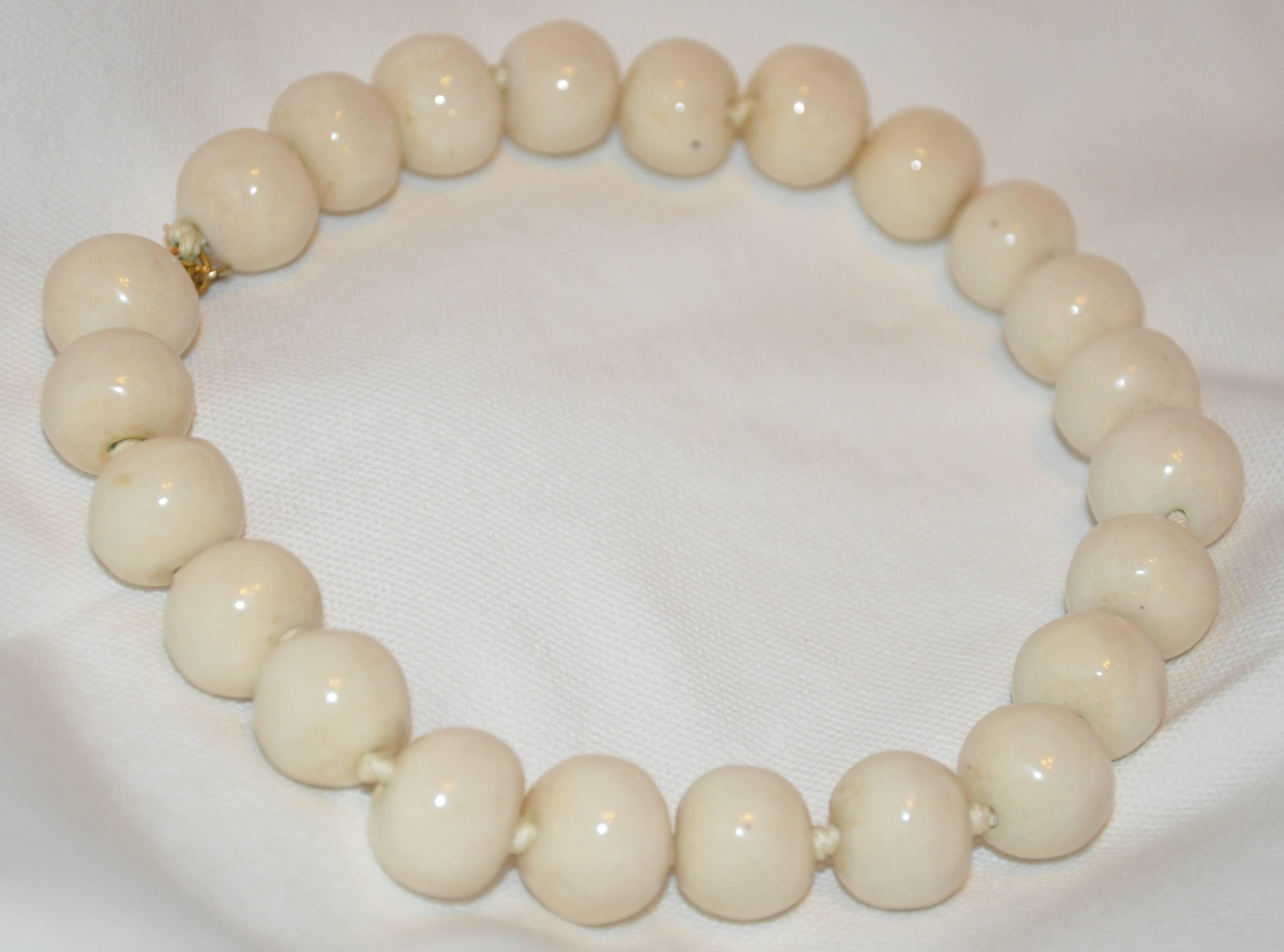        Kenneth Jay Lane whimsical chunky cream-colored hand-knotted necklace measures 15 inches in length with a width of 3/4. 