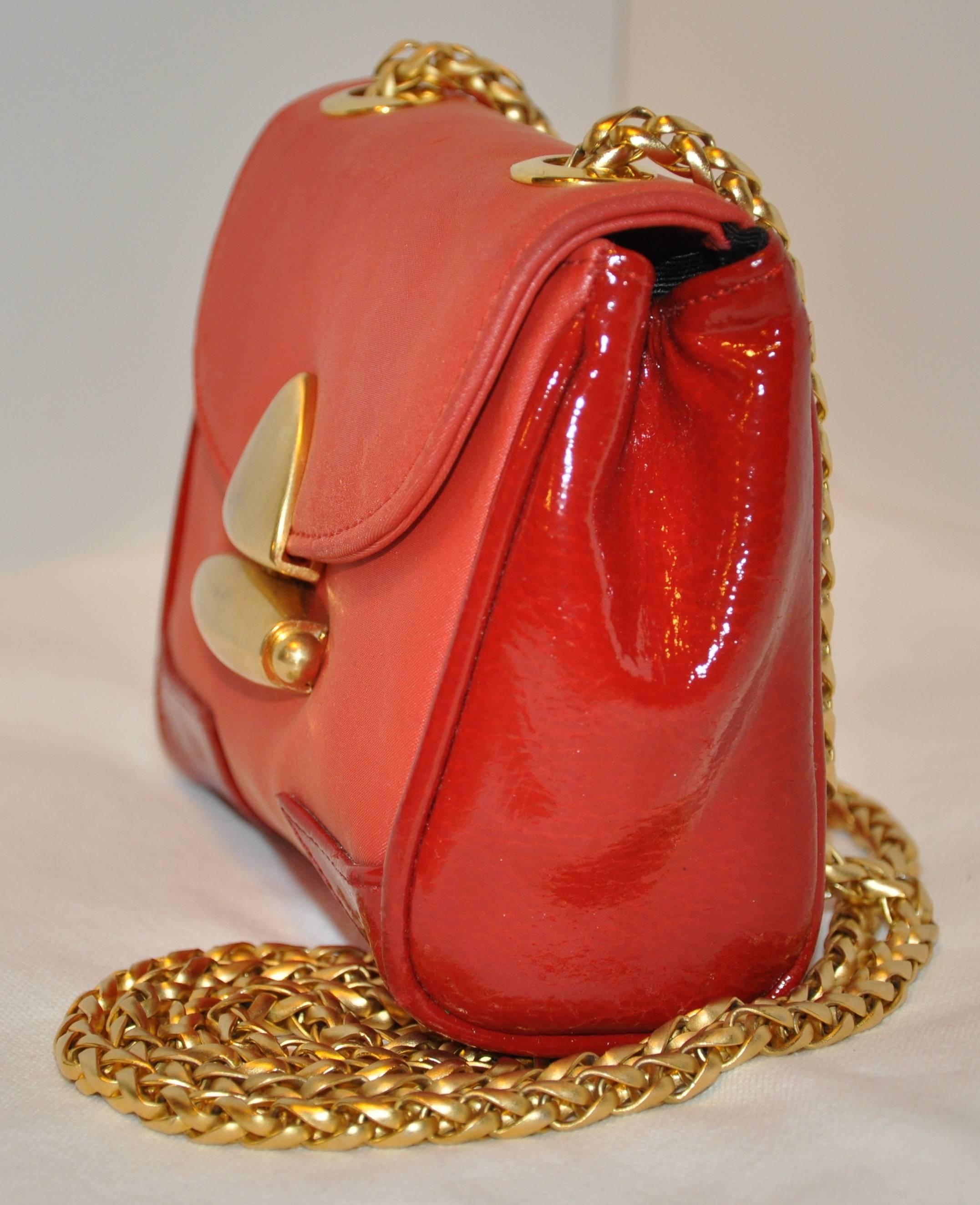        MCM wonderfully detailed miniature red with red patent leather calfskin accents evening shoulder bag is completed with gilded gold hardware on the clasp opening as well as the detailed woven thick gilded gold shoulder straps. The shoulder