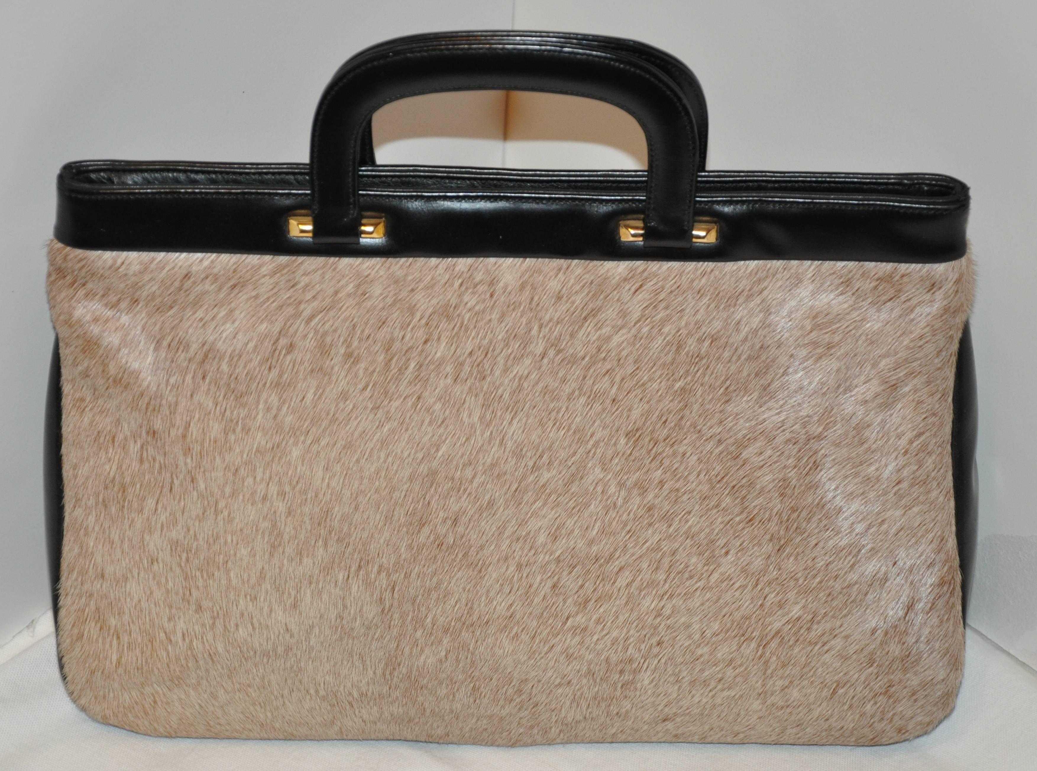        Great's wonderfully simple yet elegant natural pony-skin accented with black double handle handbag features a "spring-back" top opening which quickly closes when needed for your security. There are four brass foots on the bottom for