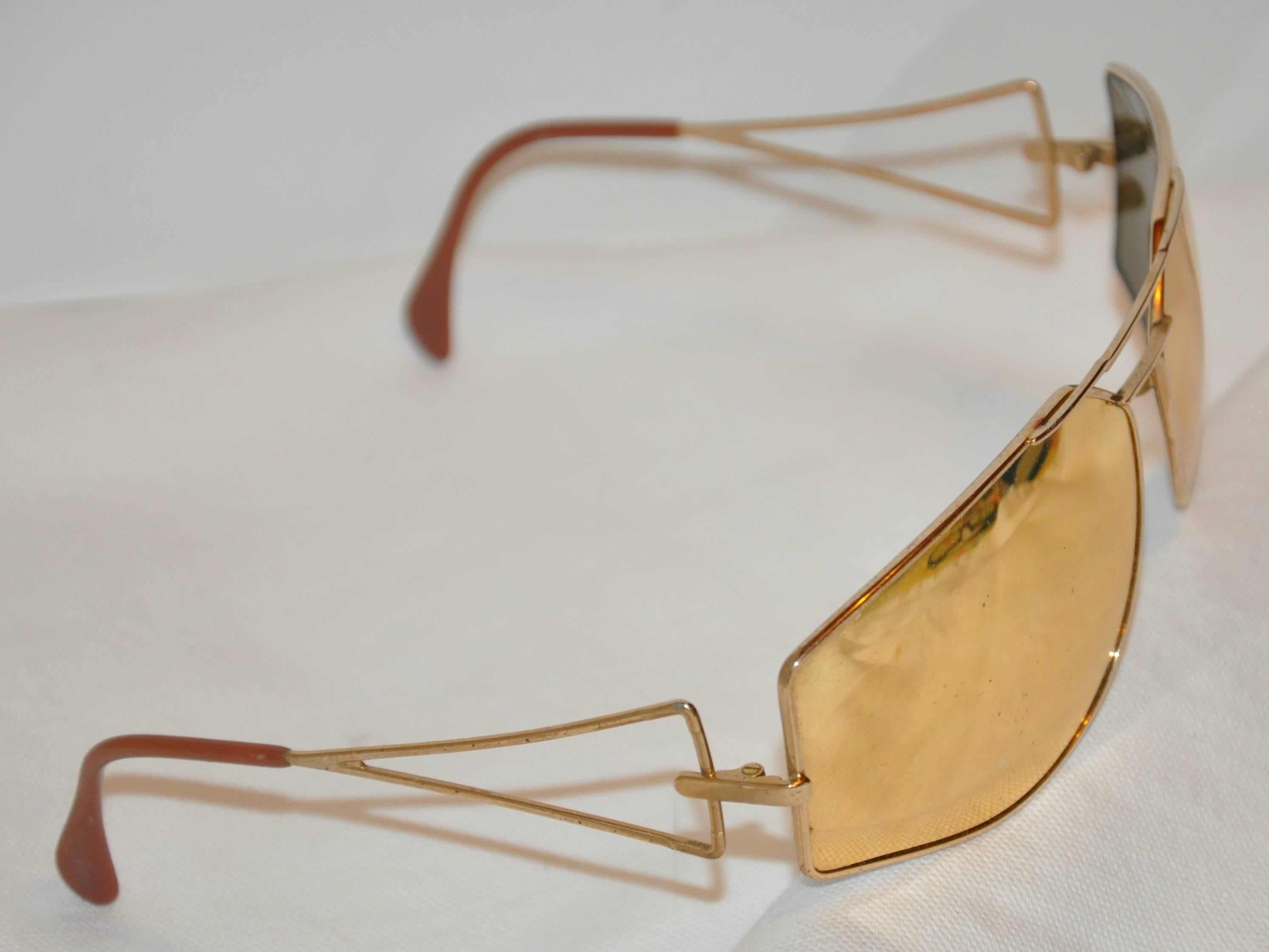        Les lunettes de soleil Silhouette à large monture en vermeil doré sont dotées d'une lentille miroir dorée et mesurent 5 5/8 pouces à l'avant. La hauteur mesure 2 pouces, avec des bras de 4 1/2 de longueur. Fabriqué en Autriche.