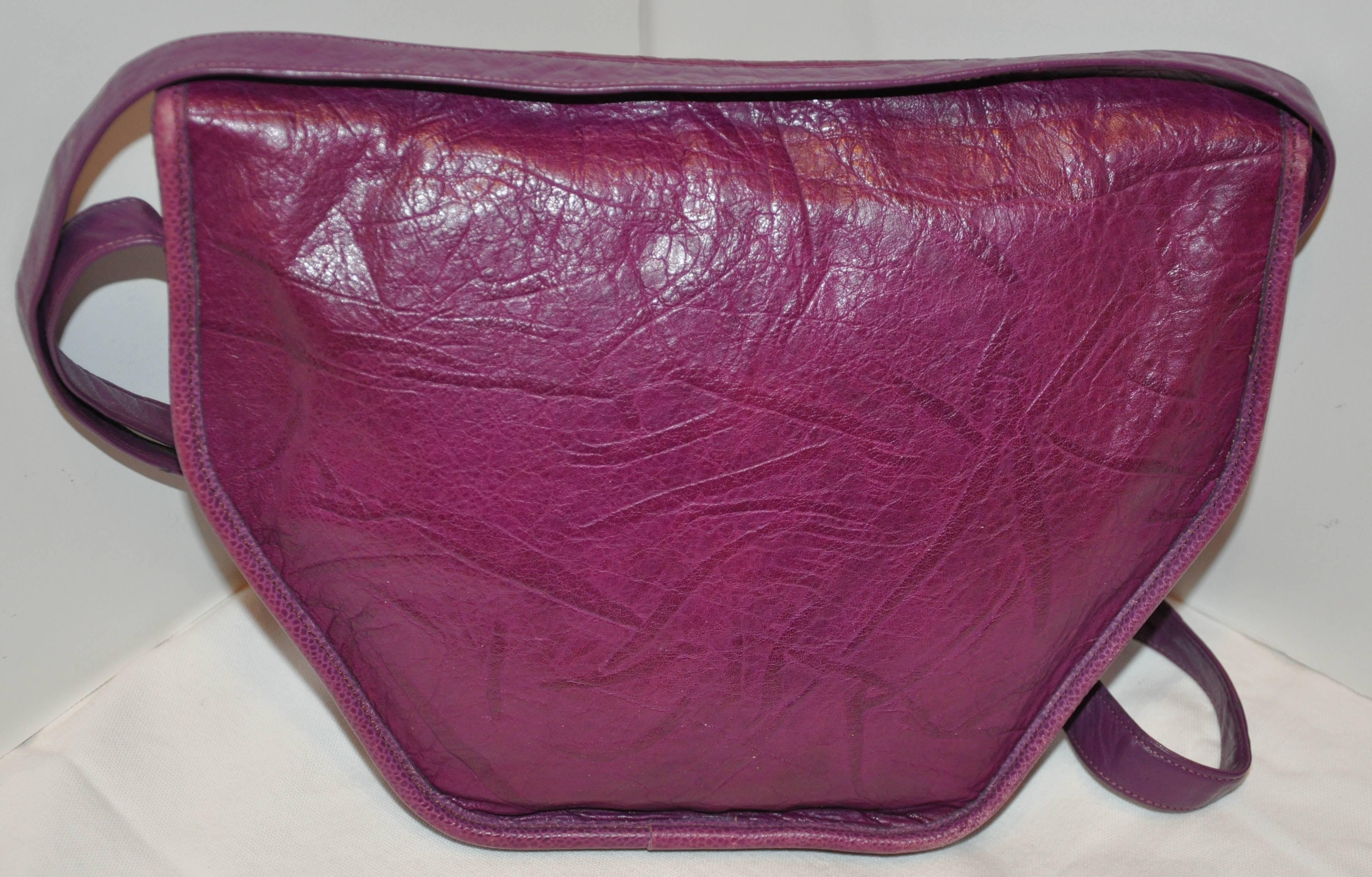        Le merveilleux sac à bandoulière Carlos Falchi en buffle violet texturé est orné du logo de la marque embossé sur le rabat avant extérieur, accentué par des alligators et des serpents embossés entourant le nom de la marque. Il y a également