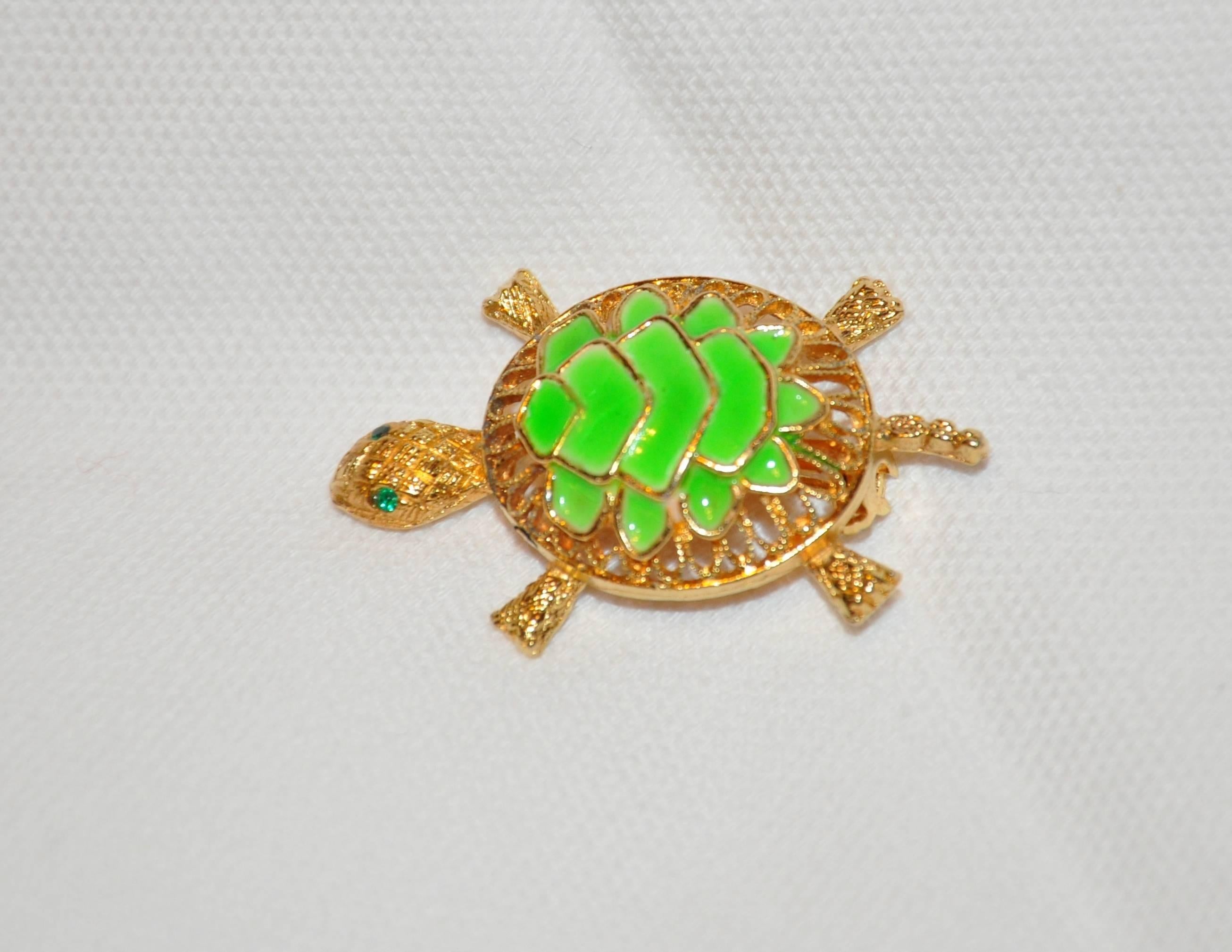        This wonderful whimsical polished gilded gold vermeil hardware "Turtle" brooch is accented with bold green enamel as well as faux emerald eyes. The length measures 1 1/4 inches, width measures 1 inch, depth is 1/2 inch. Made in US.