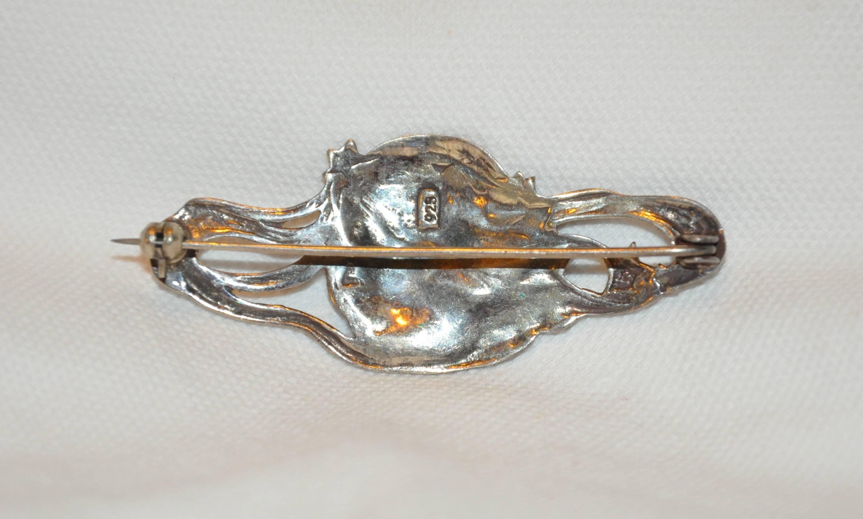        This wonderfully elegant Art Nouveau 925 sterling "Lady & Stars" brooch is accented with detailed etching of swirls surrounding the lady and stars. The width measures 2 1/2 inches, length measures 1 inch, depth is 3/8 inch, made