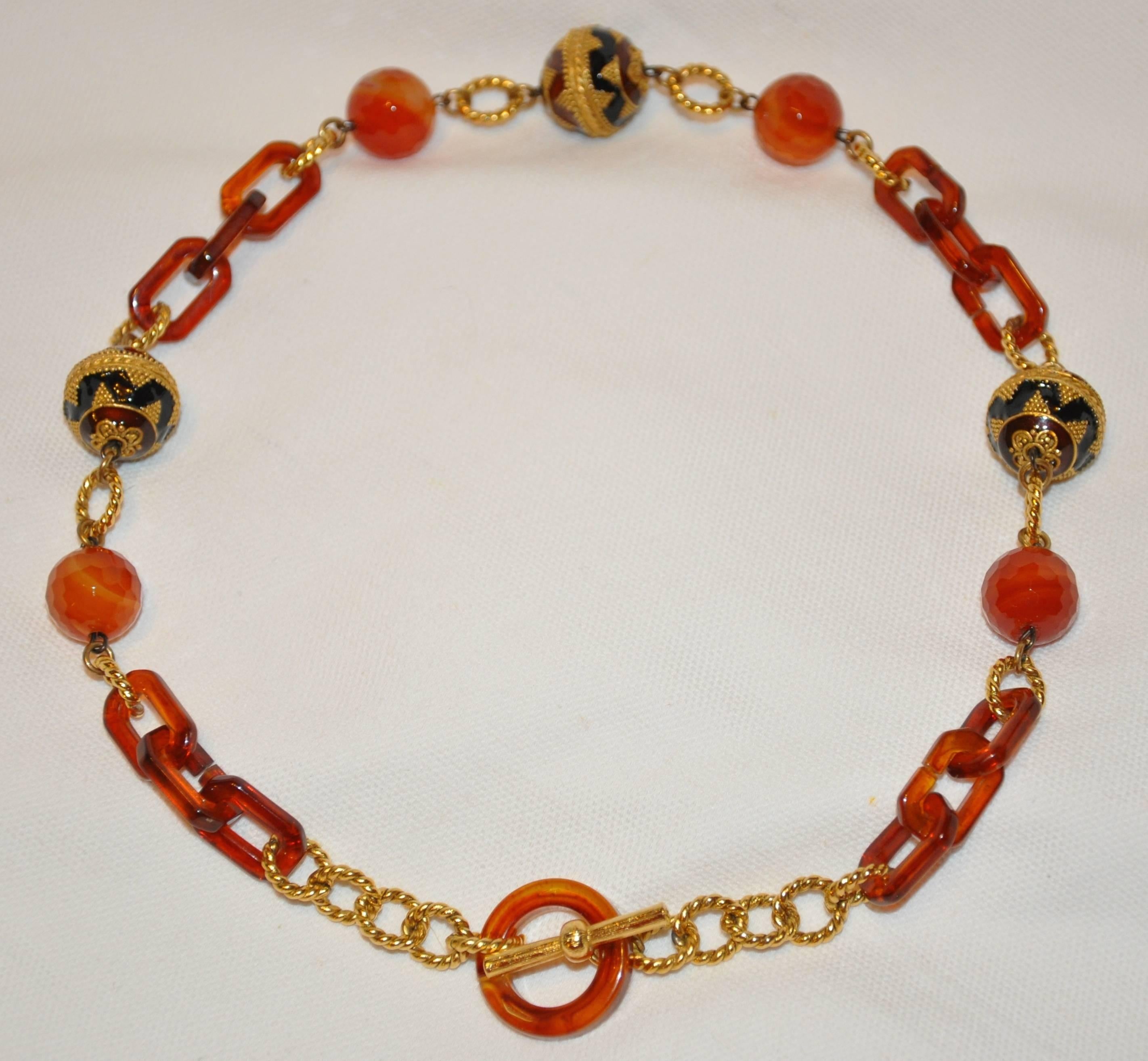        This wonderfully elegant multi textured enamel with glass and lucite necklace is perfectly combined with such detailing as polished gilded gold hardware accented with etching as well as enamel beads, amber-tone lucite and glass beads, and
