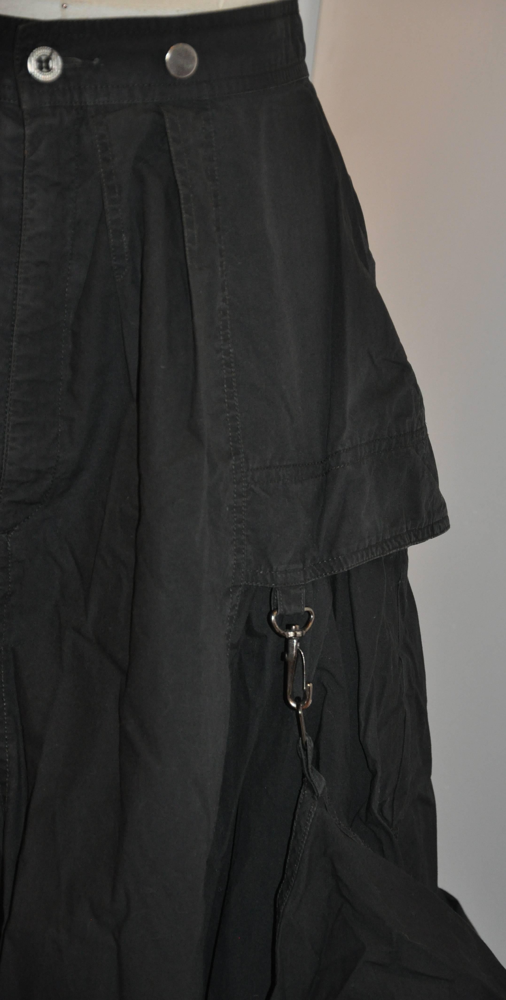      Kansai Yamamoto whimsical black cotton deconstructed skirt is detailed with two high slits on the sides under the two large side pockets. There are four optional hooks on the hem to raise both front and/or back if desired. The two large pockets
