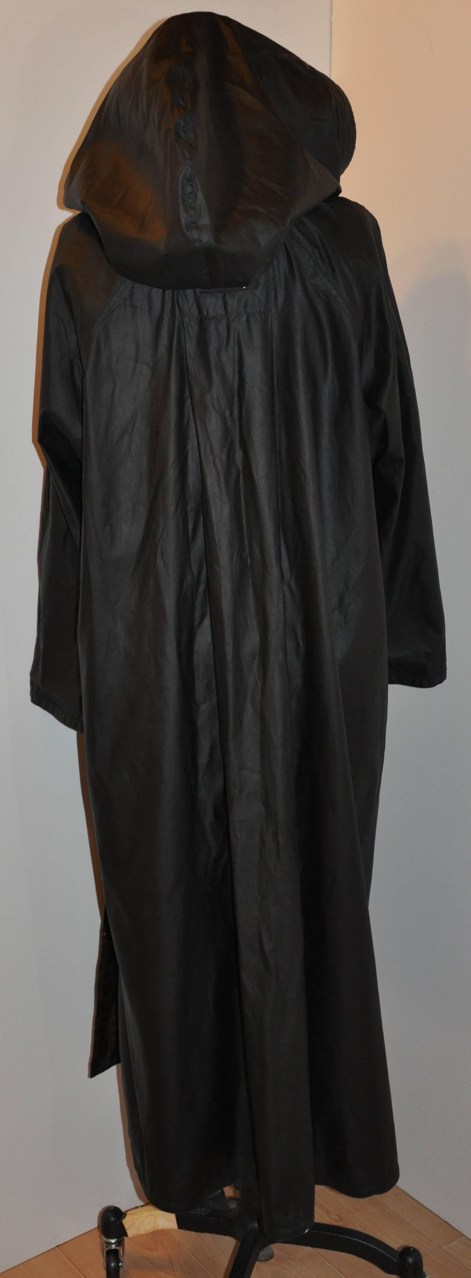      This wonderful versatile reversible floor-length over-sized hooded floor-length raincoat has the option of wearing it black, or wearing it with the leopard-print side. The center-back is accented with two soft pleats creating a dramatic