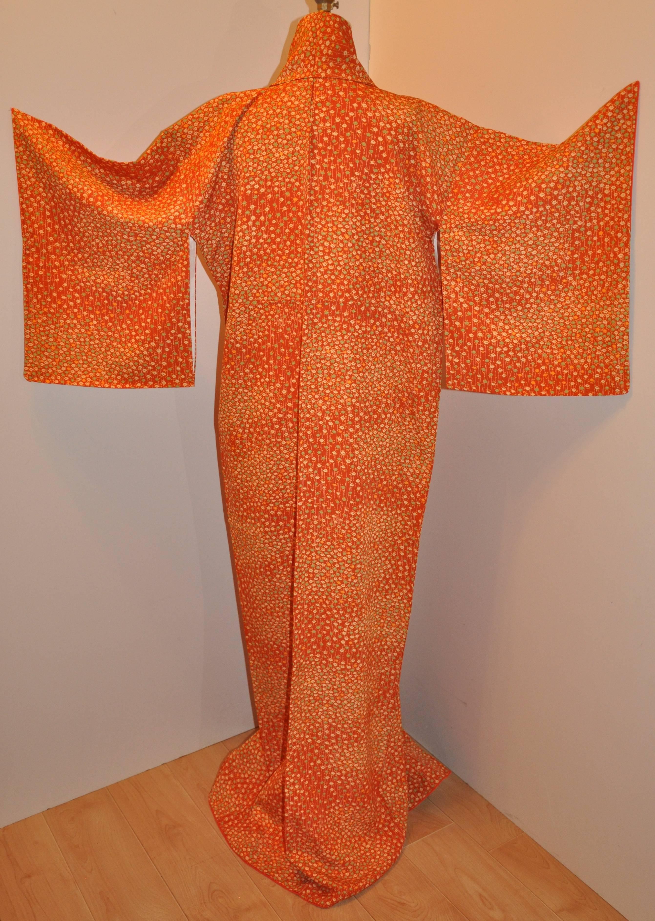    This delightfully cheerful warm tangerine silk Japanese kimono is accented with multi-micro florals and measures 63 1/4 inches in length. The underarm circumference measures 46 inches, neck-to-sleeve's-cuff is 21 1/4 inches, collar width is 4 1/2